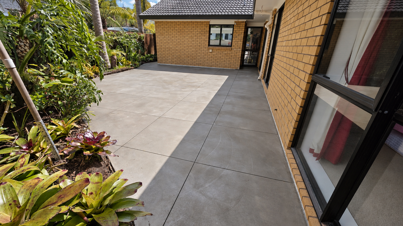 Finished trowelled concrete courtyard in West Harbour, Auckland, after acid washing and sealing.