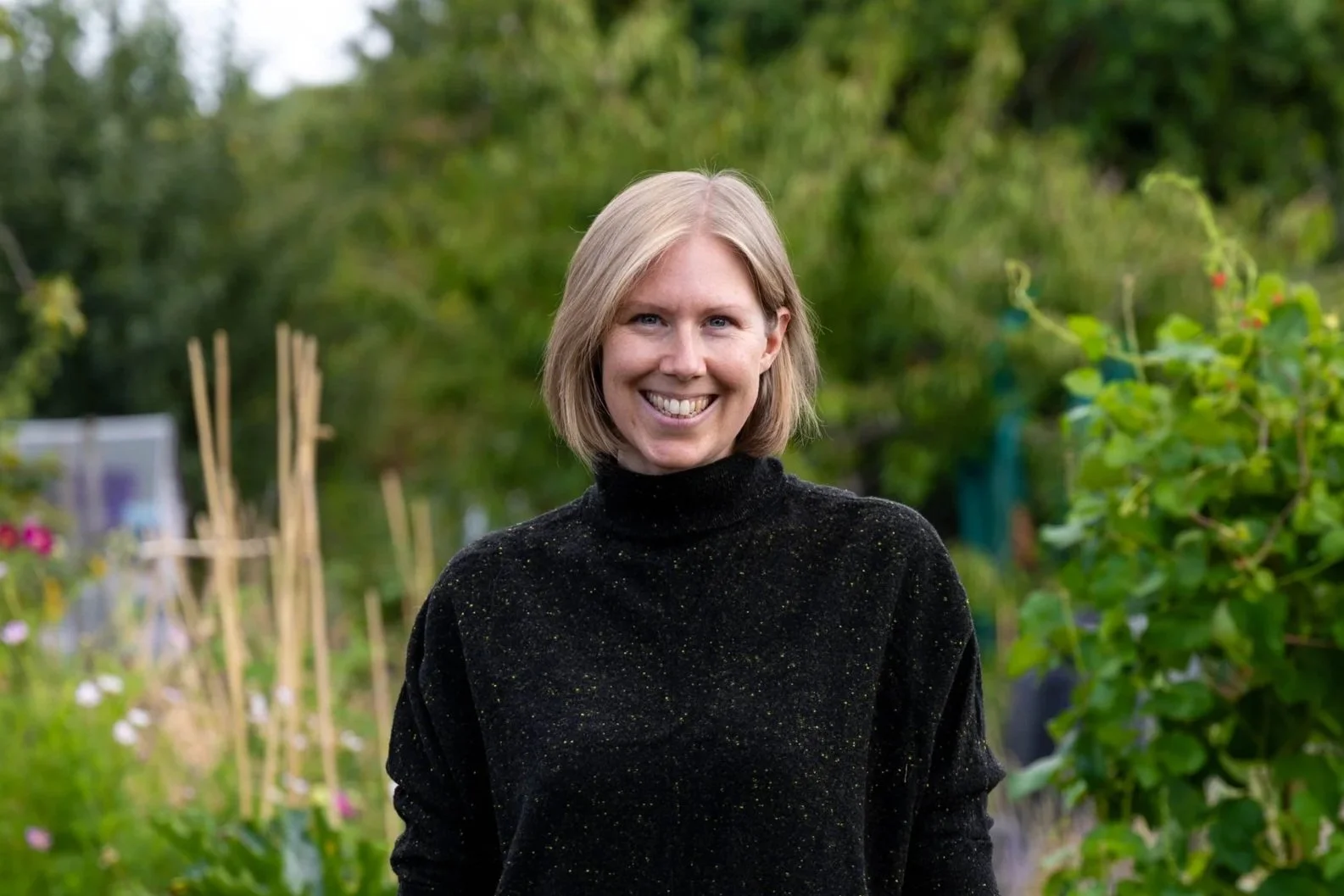 A woman called Zoë smiling in a garden