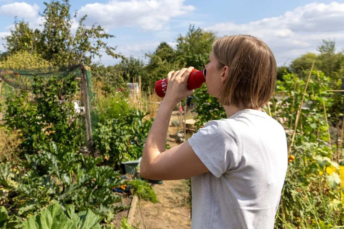 A person having a drink in a garden