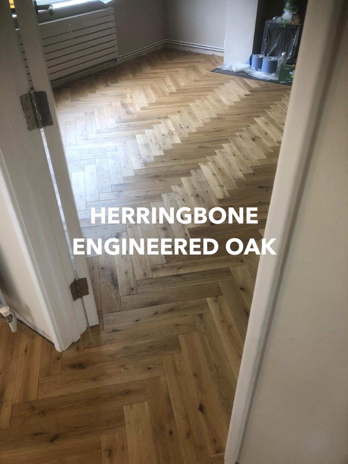 Herringbone engineered oak flooring extending through a doorway.