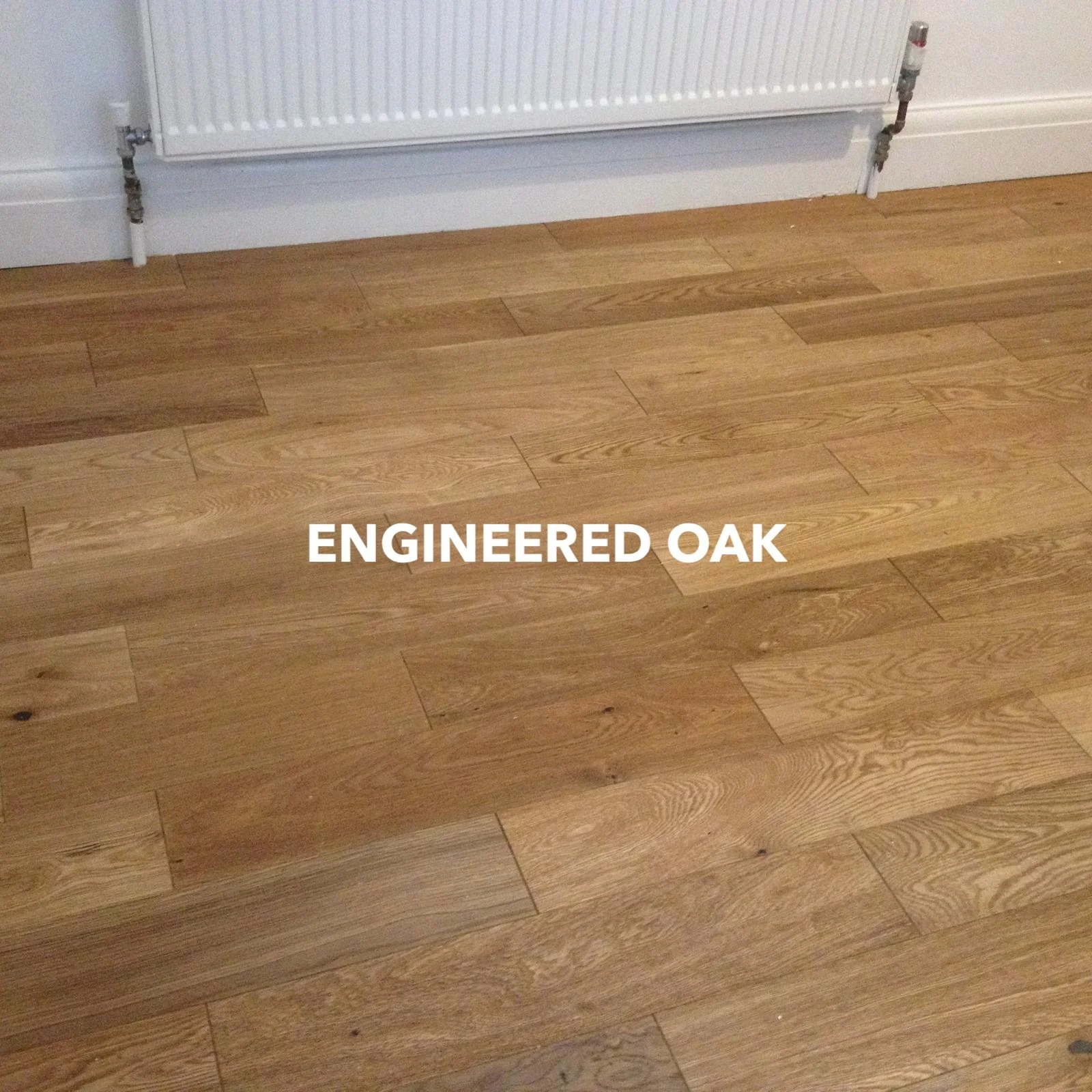 Engineered oak plank flooring beneath a white radiator.