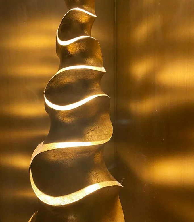 Abstract golden spiral sculpture with glowing curved bands of light