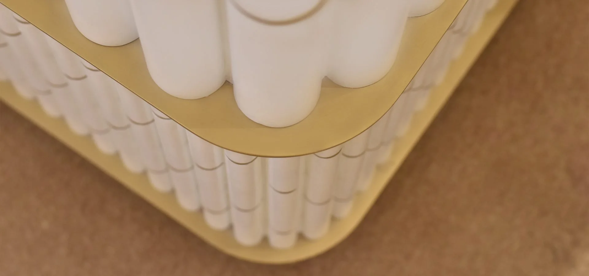 Close-up of a dental model showing white teeth on a gold base