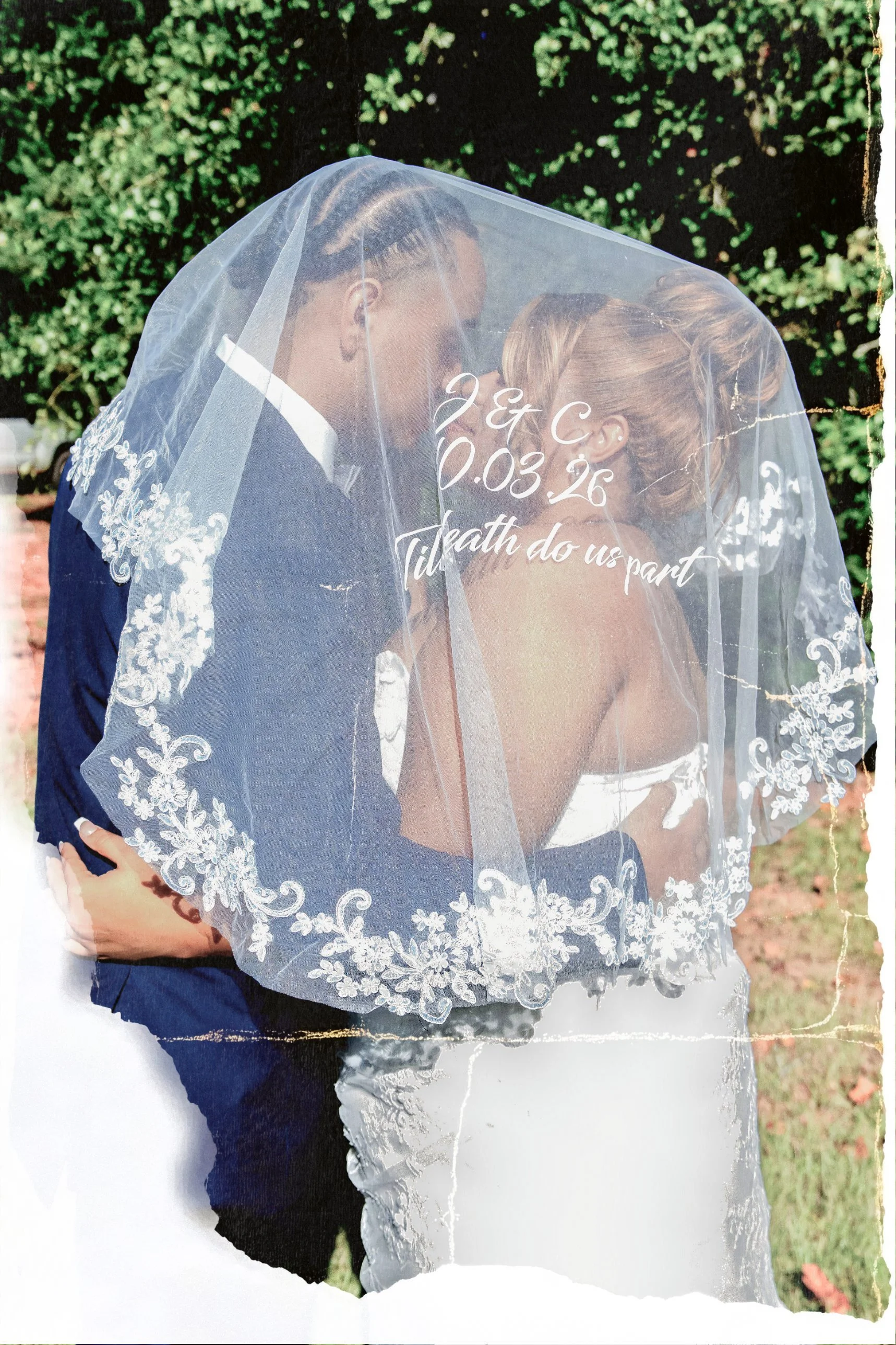 Bride and groom kissing beneath a lace veil