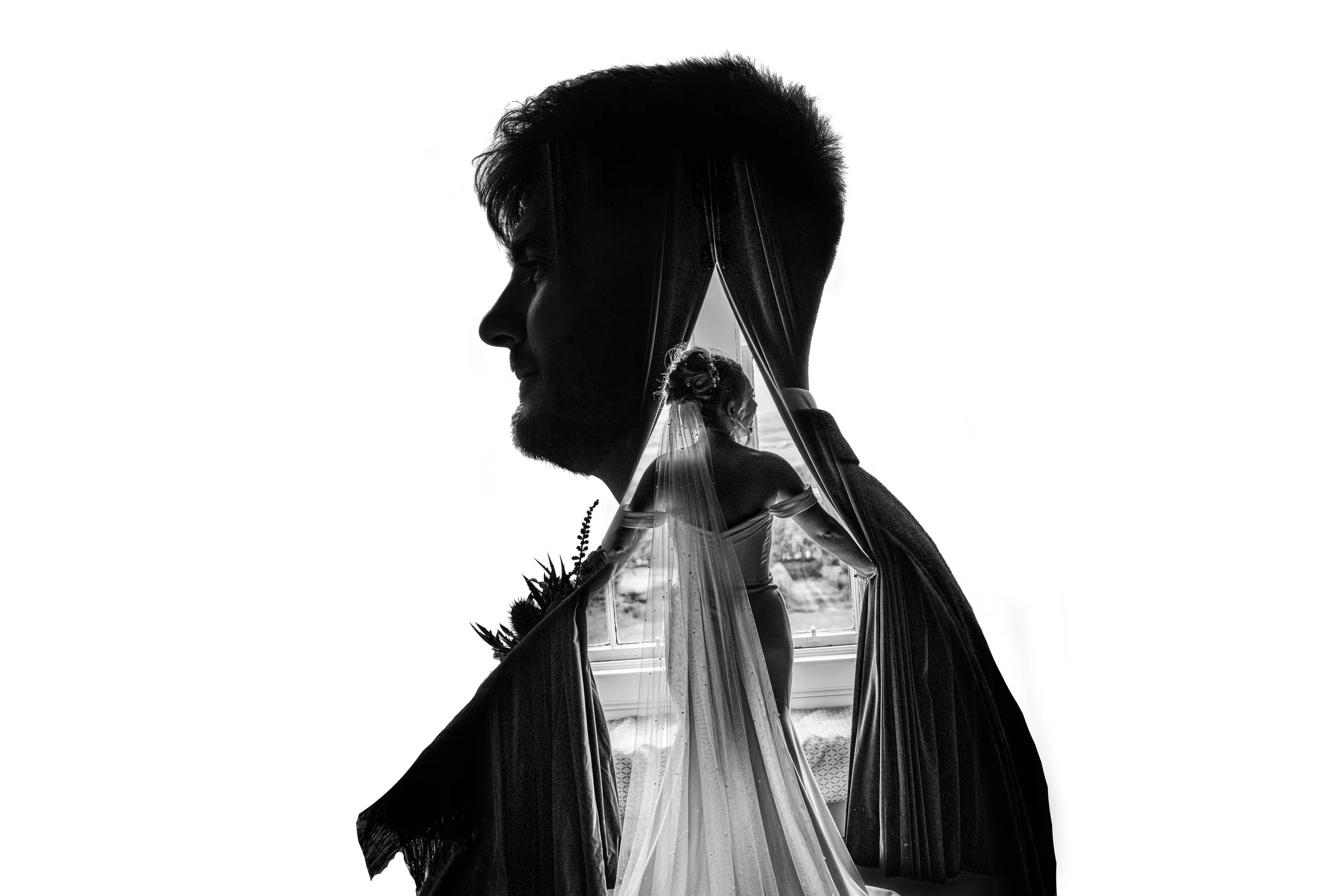 A double exposure black-and-white photo featuring a man with a beard and spiked hair, and a woman dressed in wedding attire holding a bouquet, with a window and landscape in the background.