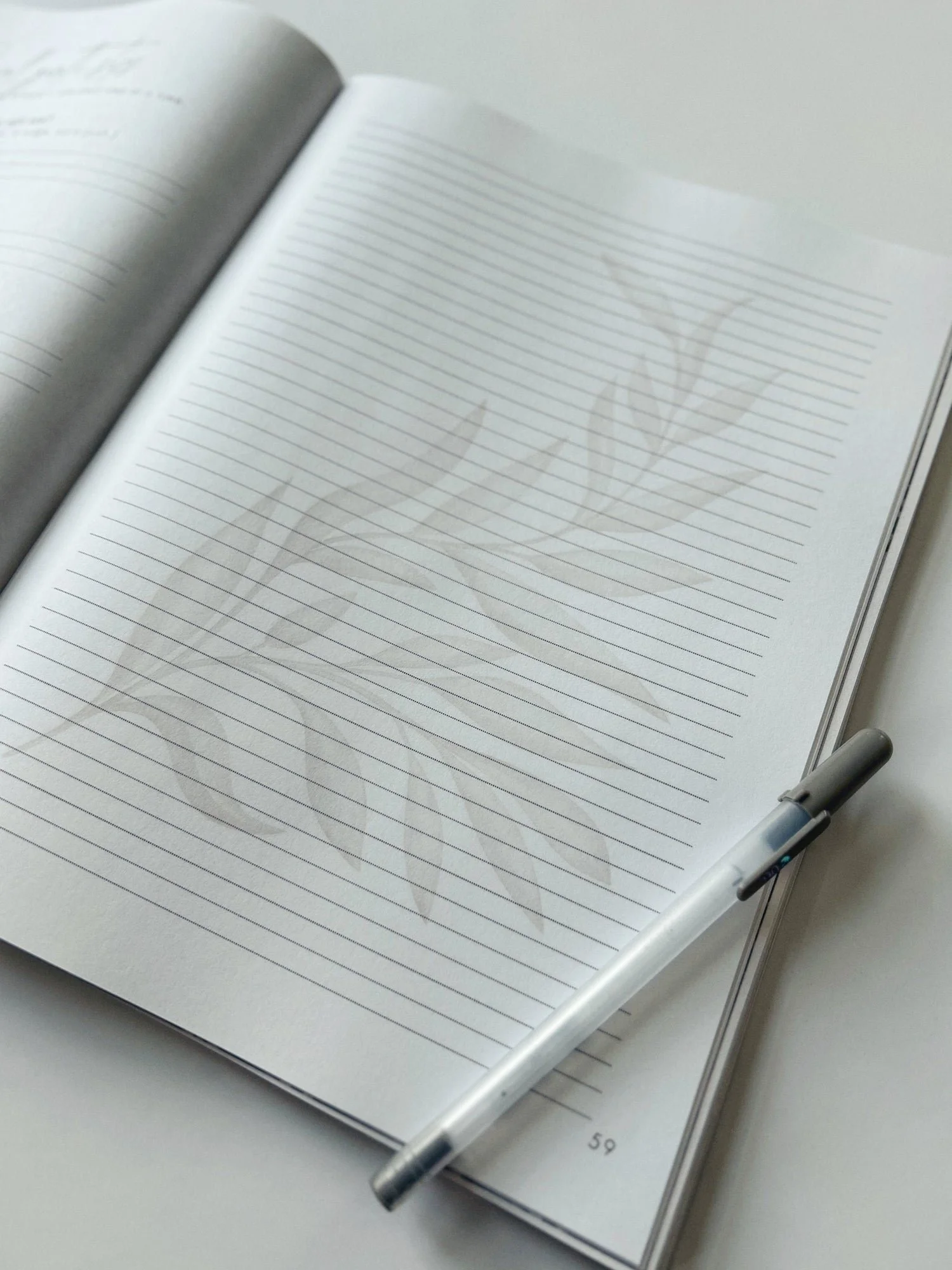 An open journal with a watercolor leaf and a pen, ready for a few honest lines