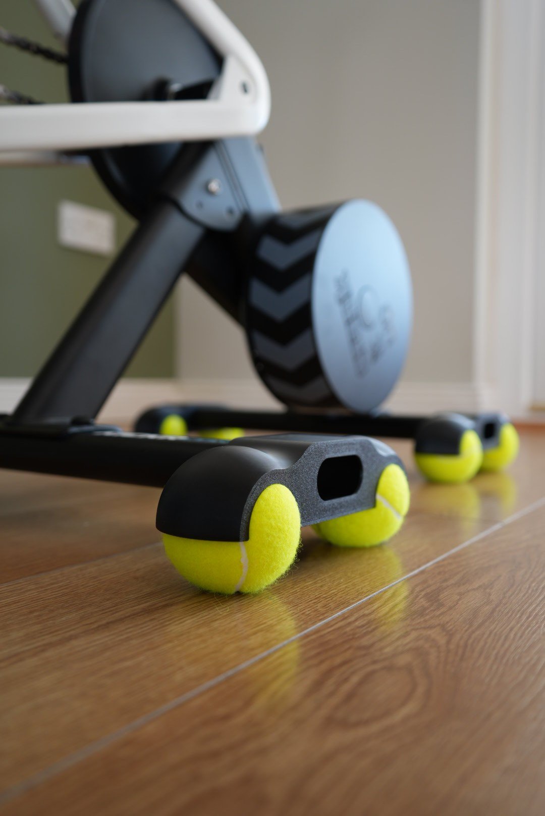 Rocker feet fitted to a Wahoo KICKR CORE 2, each foot sitting on two tennis balls