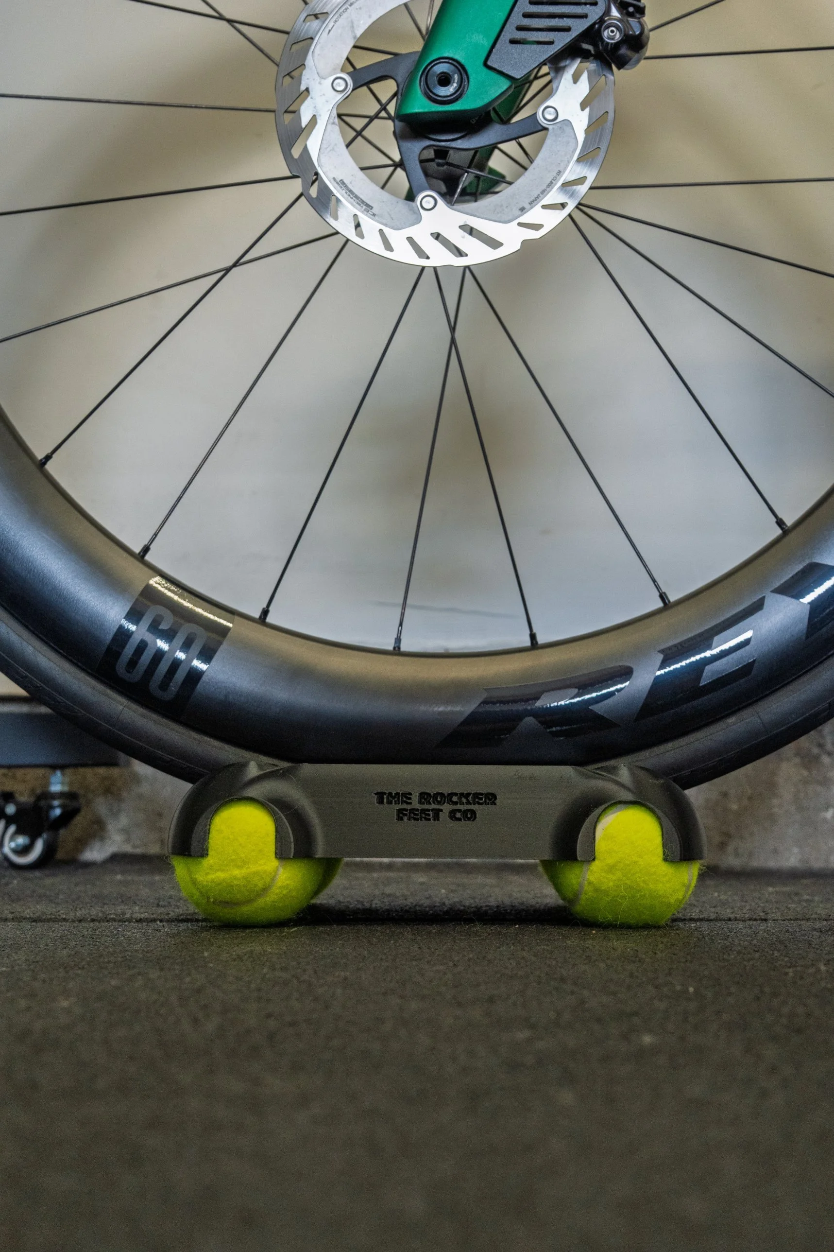 Front Wheel Rocker under a road bike wheel, sitting on two tennis balls