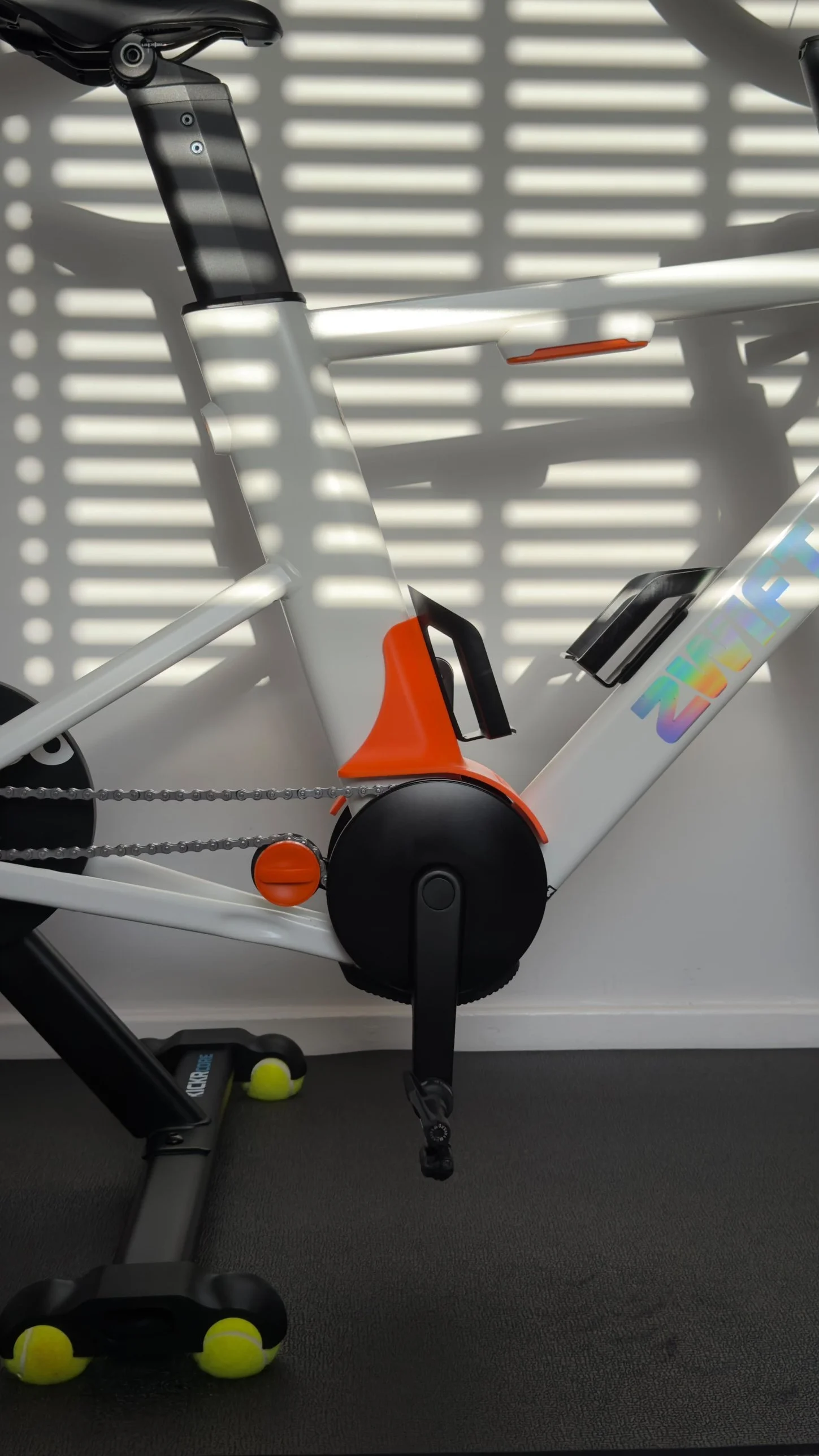 Zwift Ride on a Wahoo KICKR CORE with an orange Rocker Feet Co. crank cover and rocker feet on tennis balls