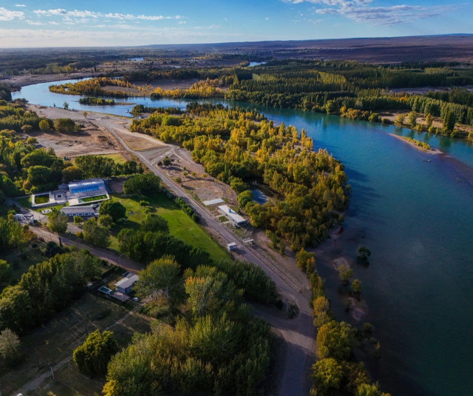 Vista aérea de Plottier, provincia de Neuquén, Argentina, con el río Limay, vegetación y áreas residenciales.