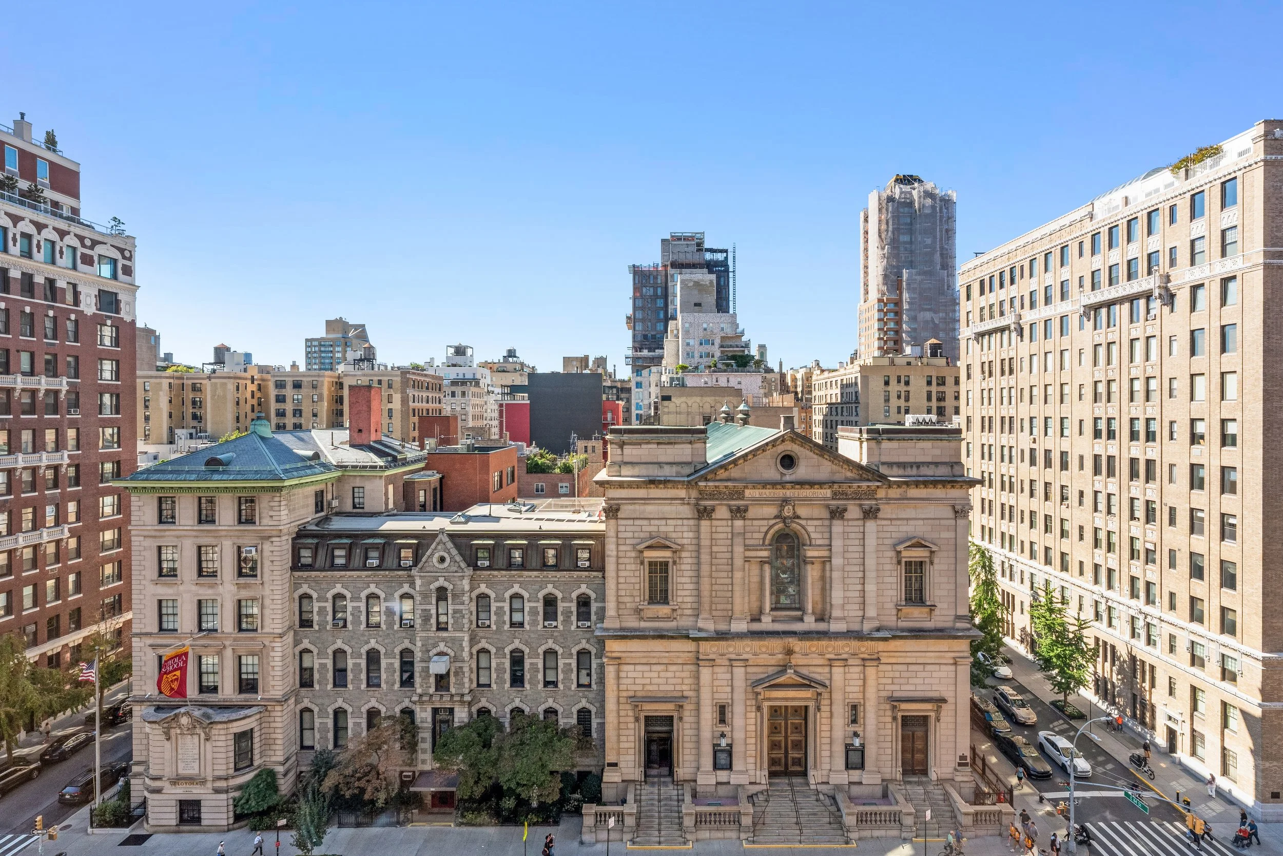 Cityscape featuring historic and modern buildings under a clear blue sky.