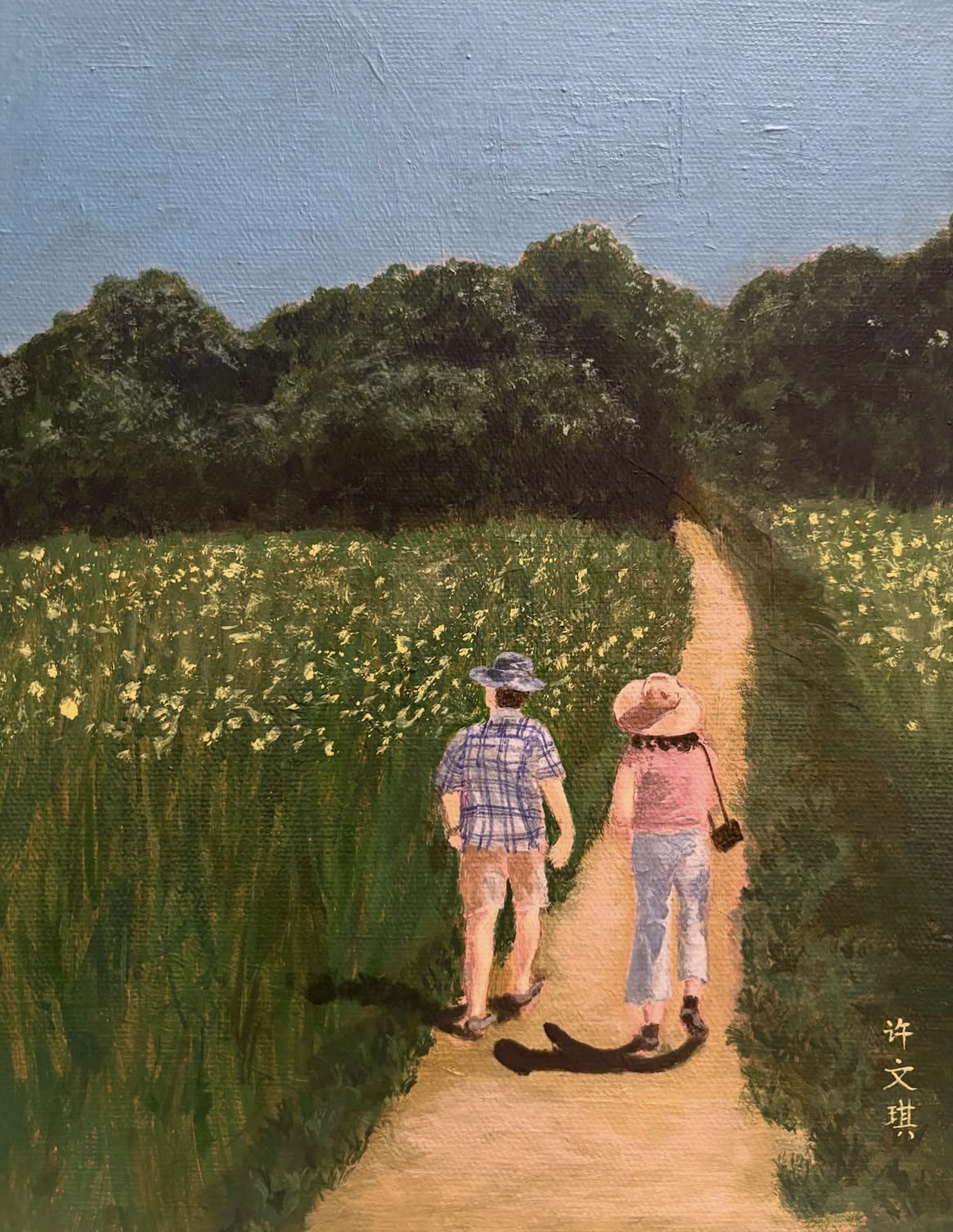 a Chinese couple walks through a field on a summer day along a sandy dirt path flanked by green grass and yellow flowers