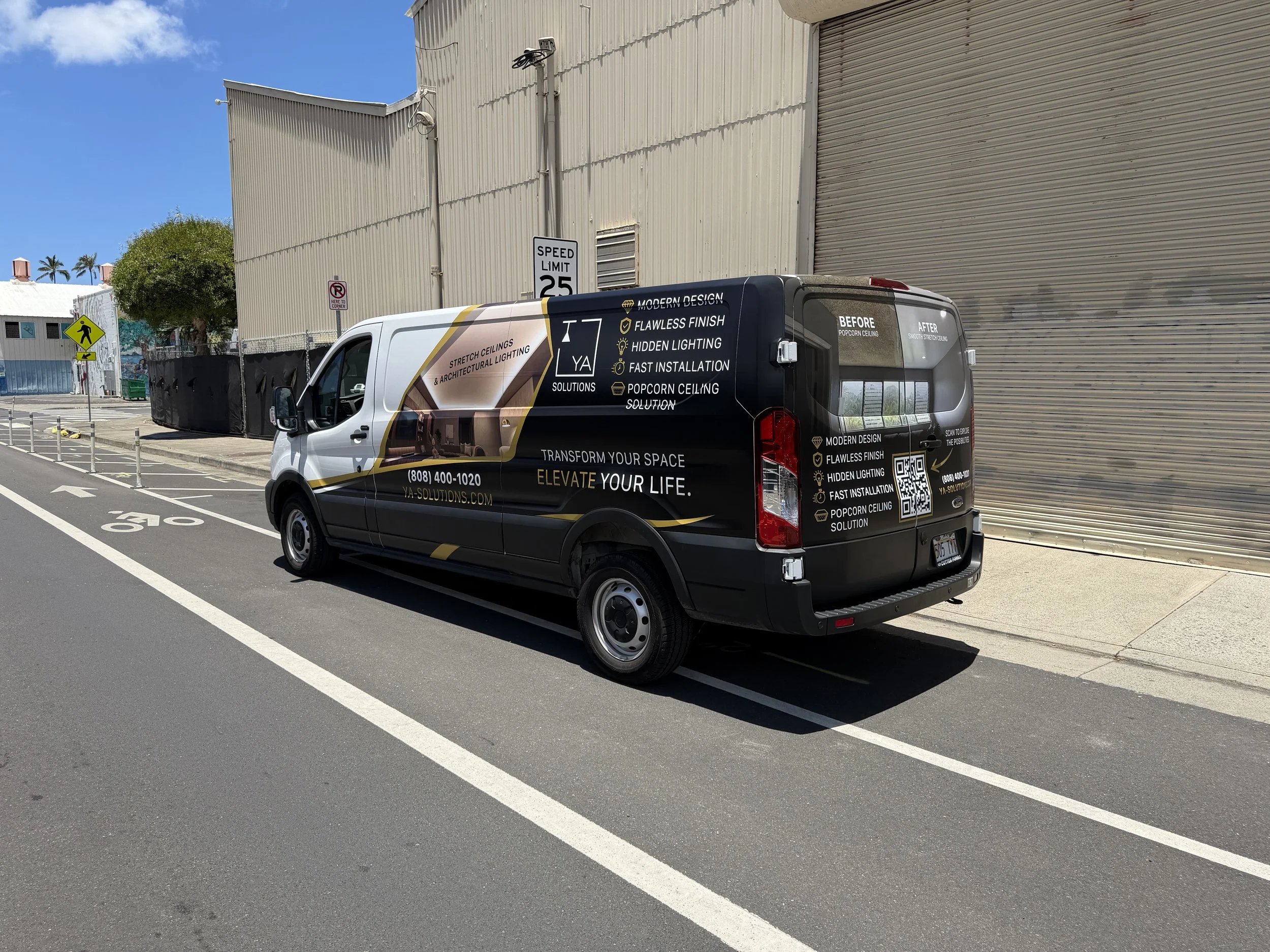 Branded YA Solutions van advertising stretch ceilings and popcorn ceiling solutions parked outside an industrial building.