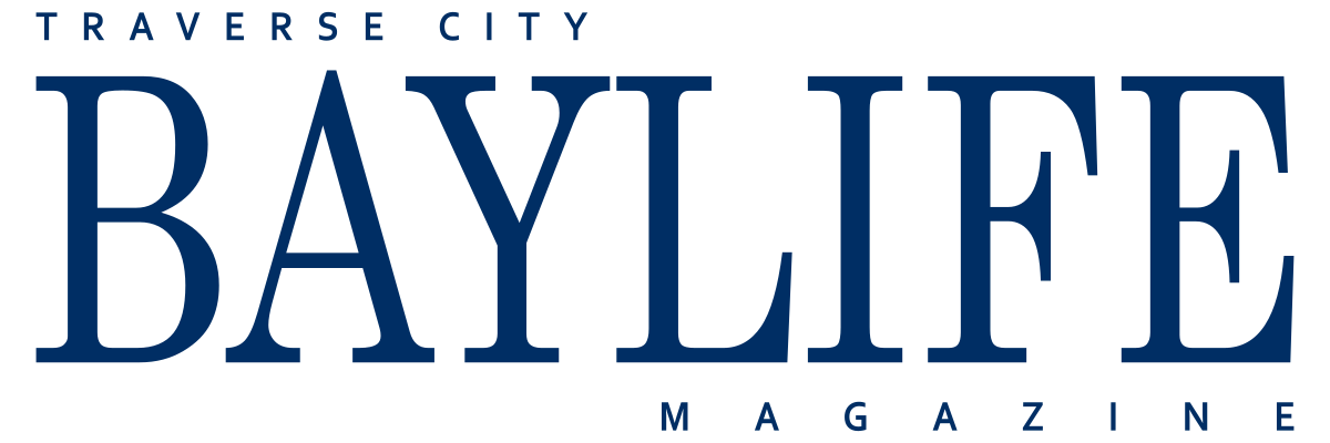 Logo of Traverse City Baylife Magazine in blue text with 'Traverse City' at the top, 'Baylife' in large bold letters in the middle, and 'Magazine' at the bottom.