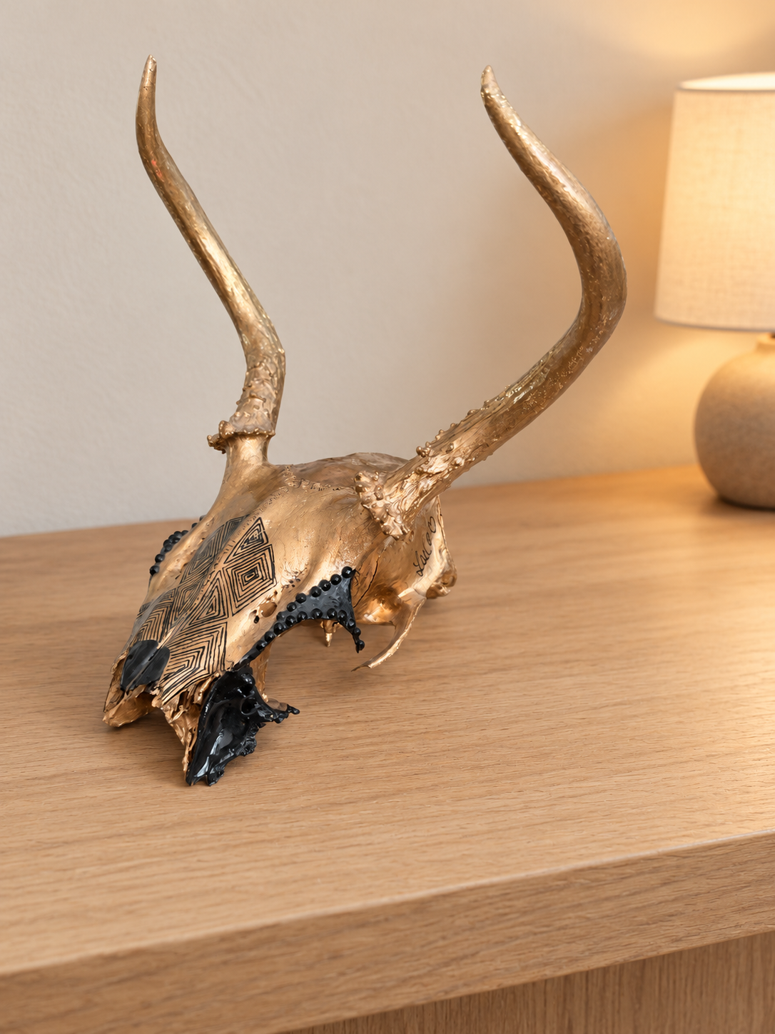 Golden deer skull on ivory console.png