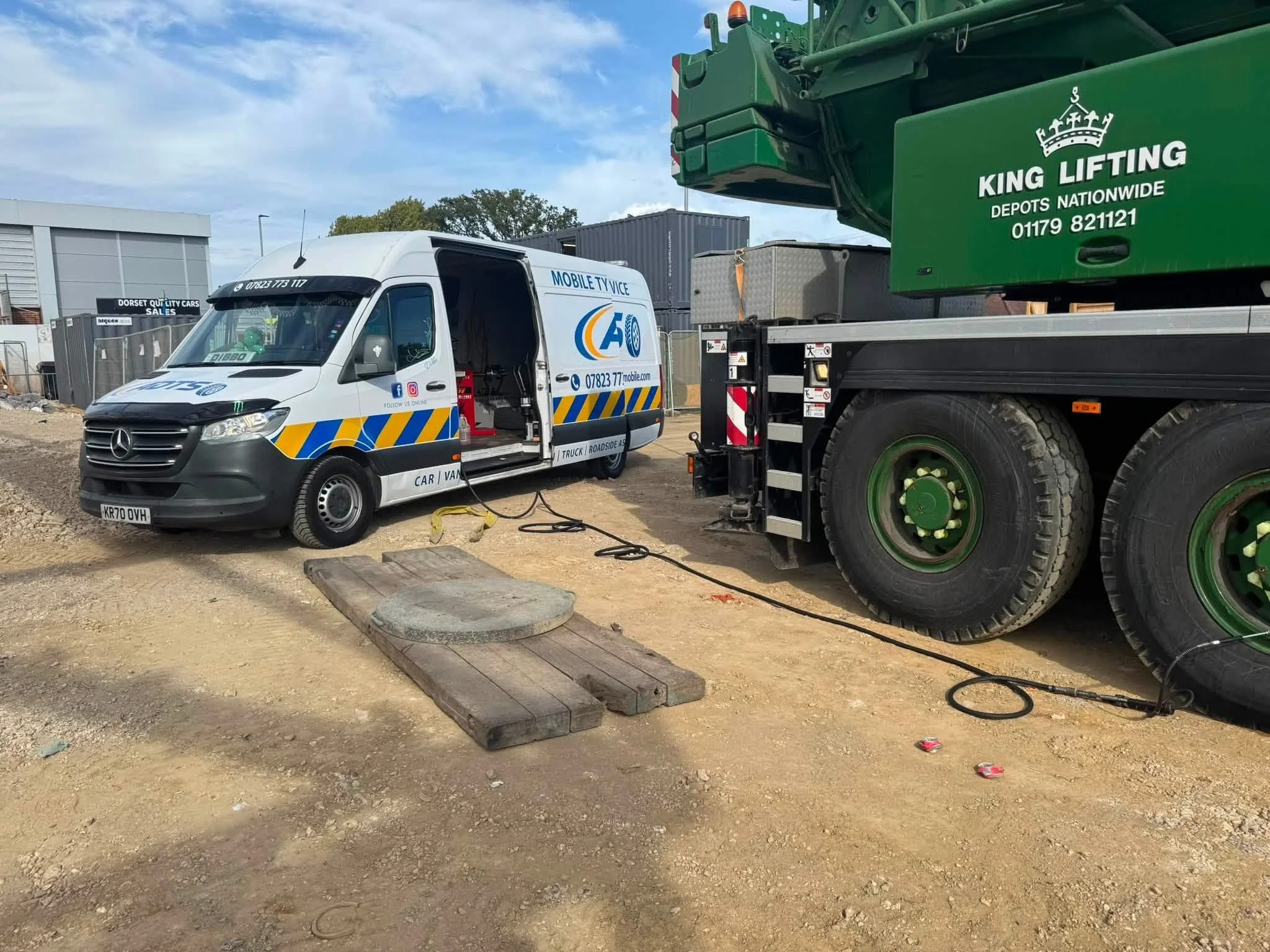 A white mobile TV service van parked on a construction site with a large green crane lifting a container. The van is marked with the logo 'ATSO' and contact information, and the crane has the brand 'King Lifting' written on it.