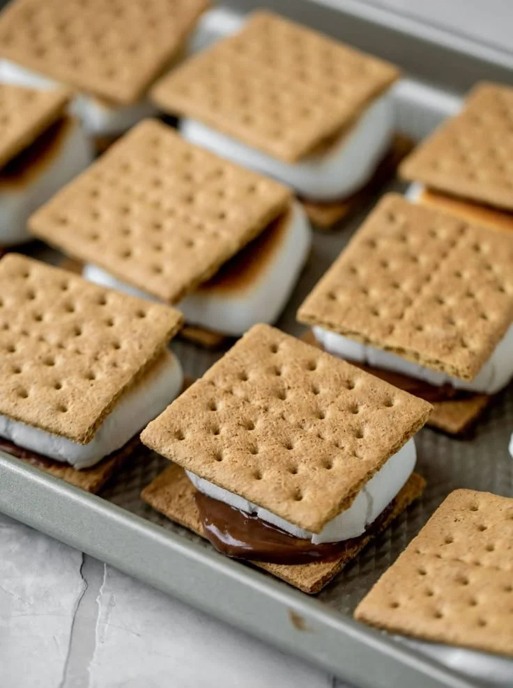 Galletas saladas con relleno de crema y chocolate en una bandeja.