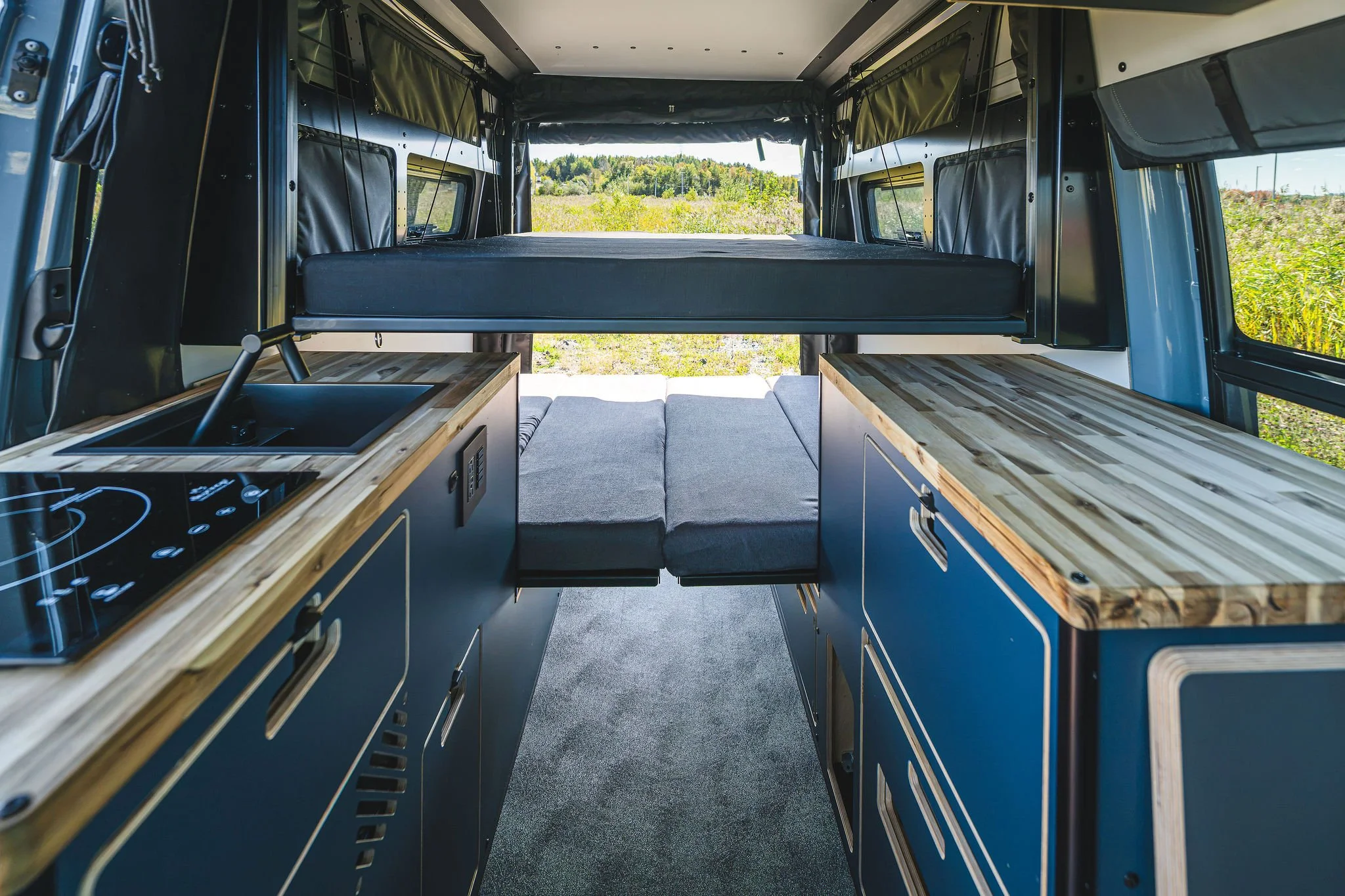 Vue intérieure du Hervé G2 avec cuisine, comptoirs en bois, rangements intégrés et espace de vie modulable.