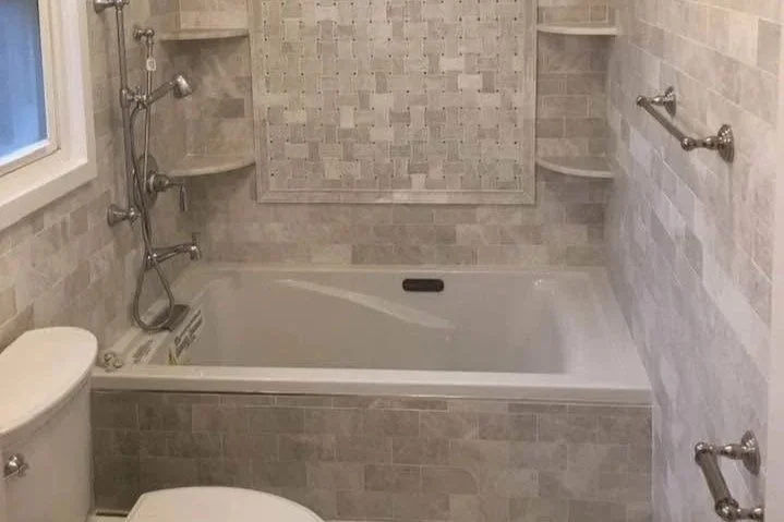 Bathroom with bathtub, shower fixtures, window, and tiled walls.