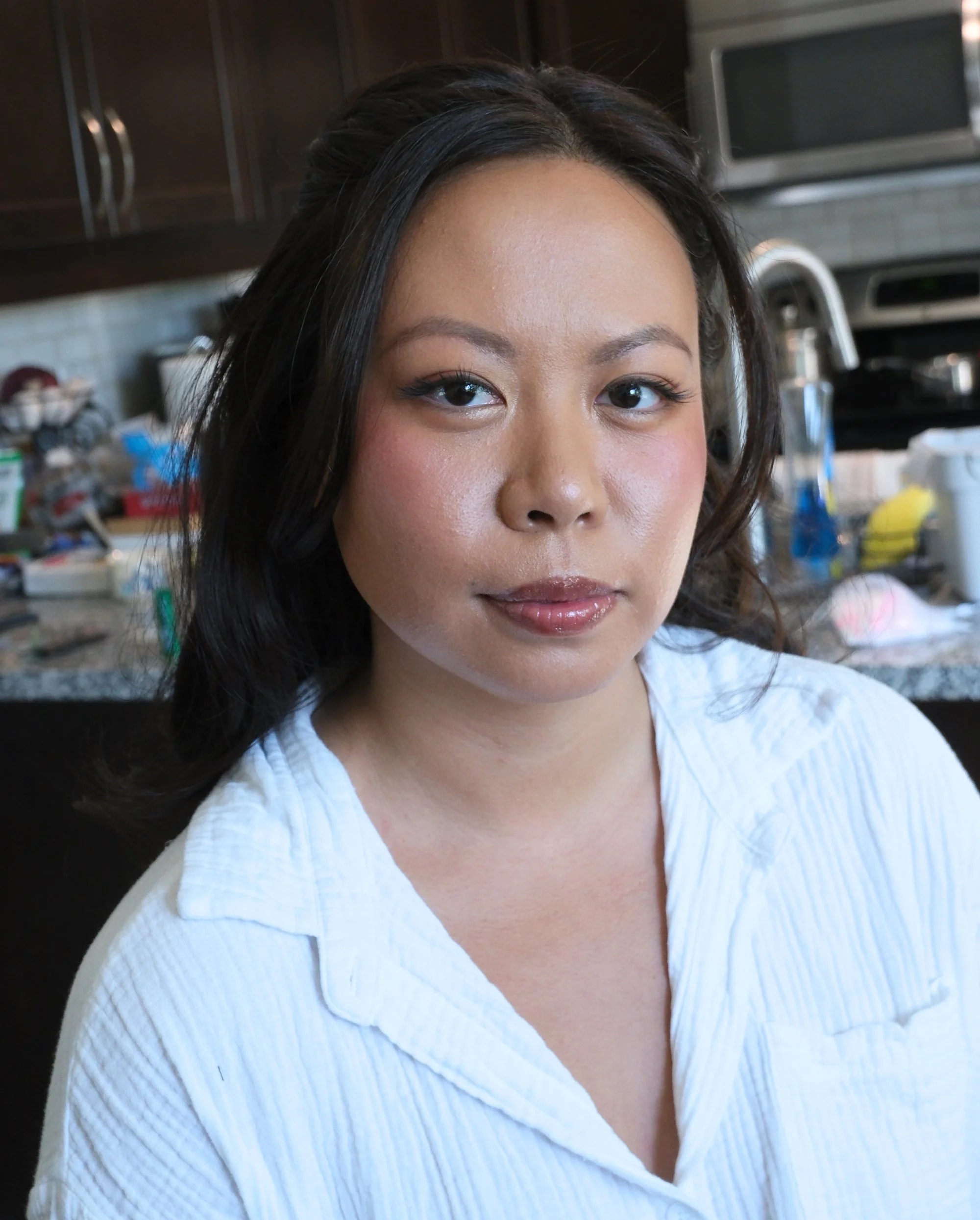 Bride wearing glowing natural bridal makeup with rosy pink blush for a soft, blushing-bride effect.