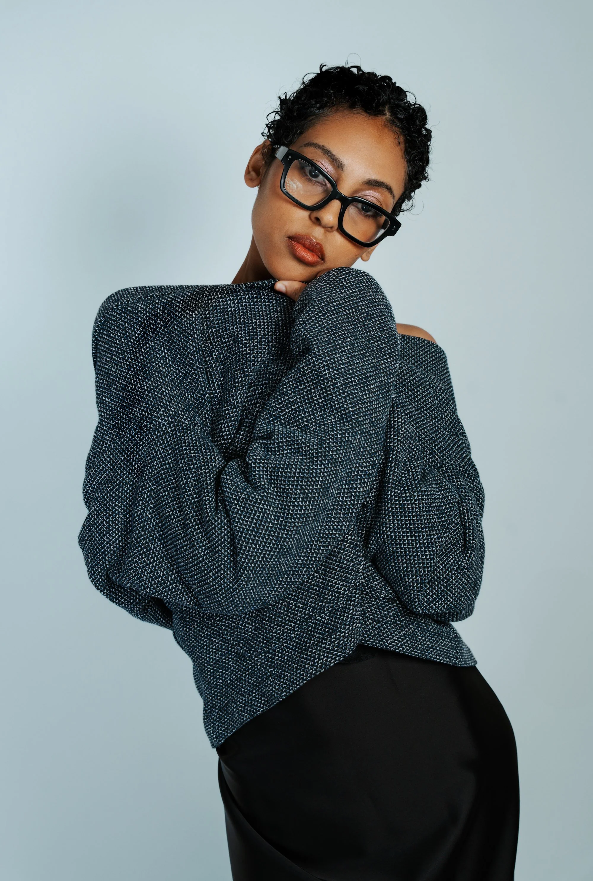 Model with a medium skin tone wearing pink shimmer eye makeup and bold red lipstick 