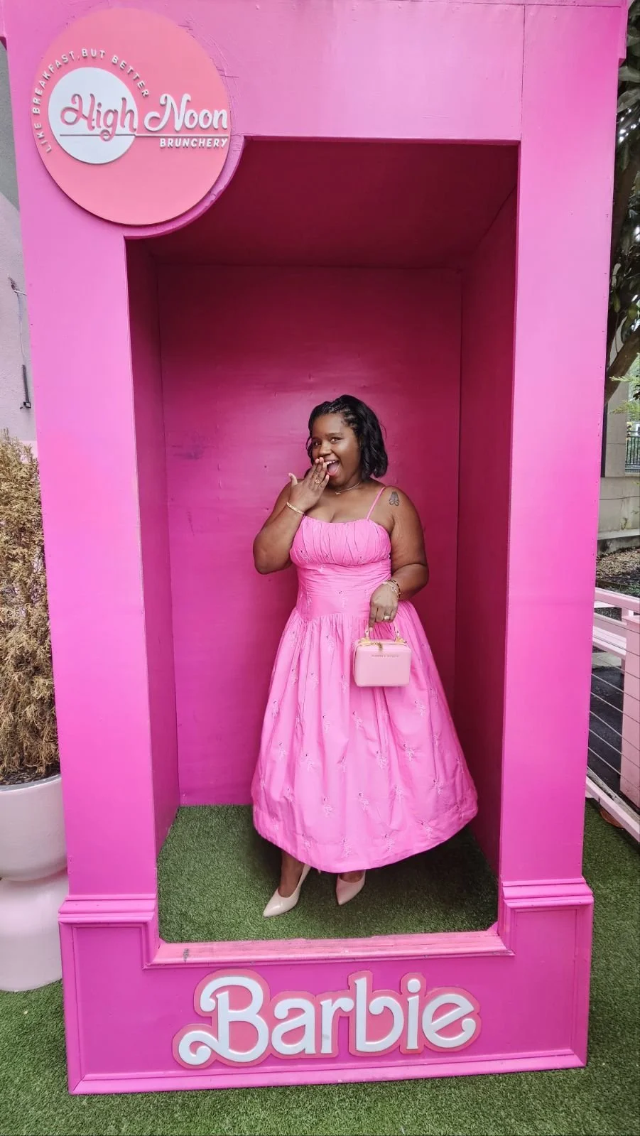 Keena wearing a pink dress inside a life-size Barbie box at High Noon Brunchery.