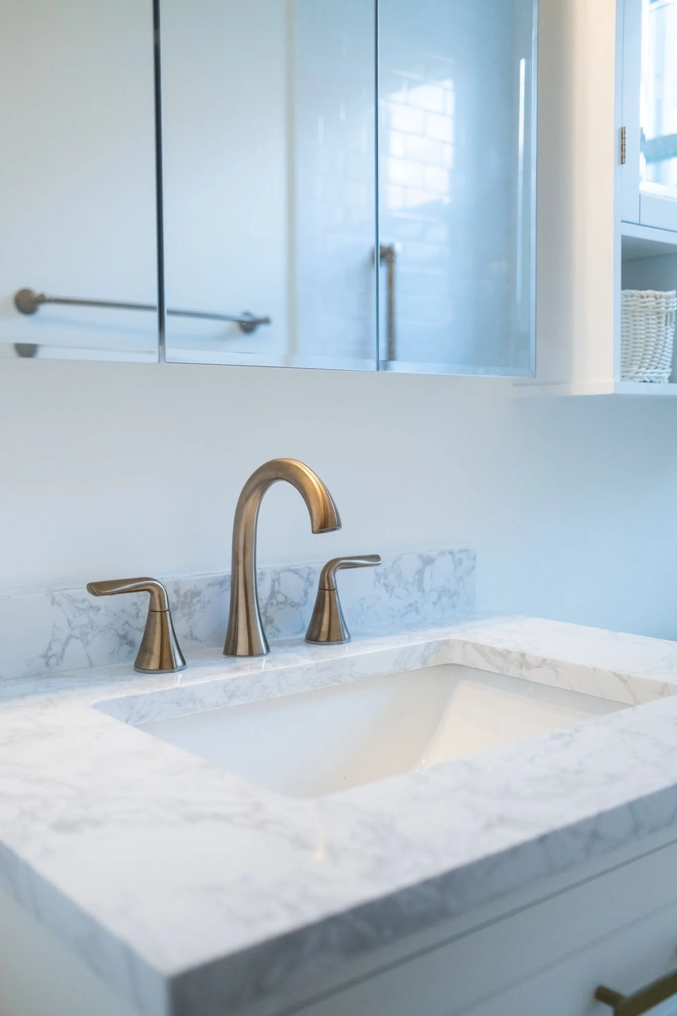Stone vanity top with brushed bronze faucet