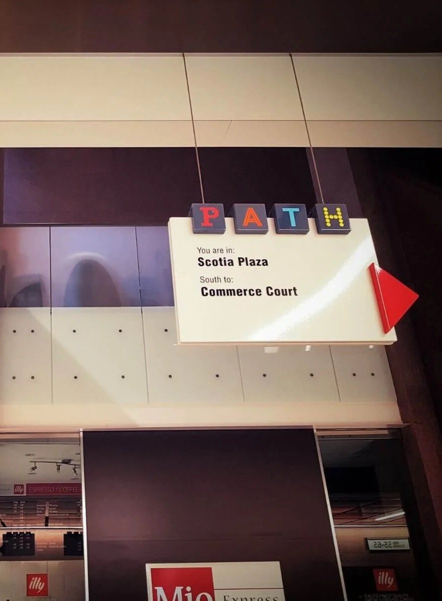 Sign in Scotia Plaza indicating directions to Commerce Court, with the word 'PATH' spelled out in letter blocks hanging above.