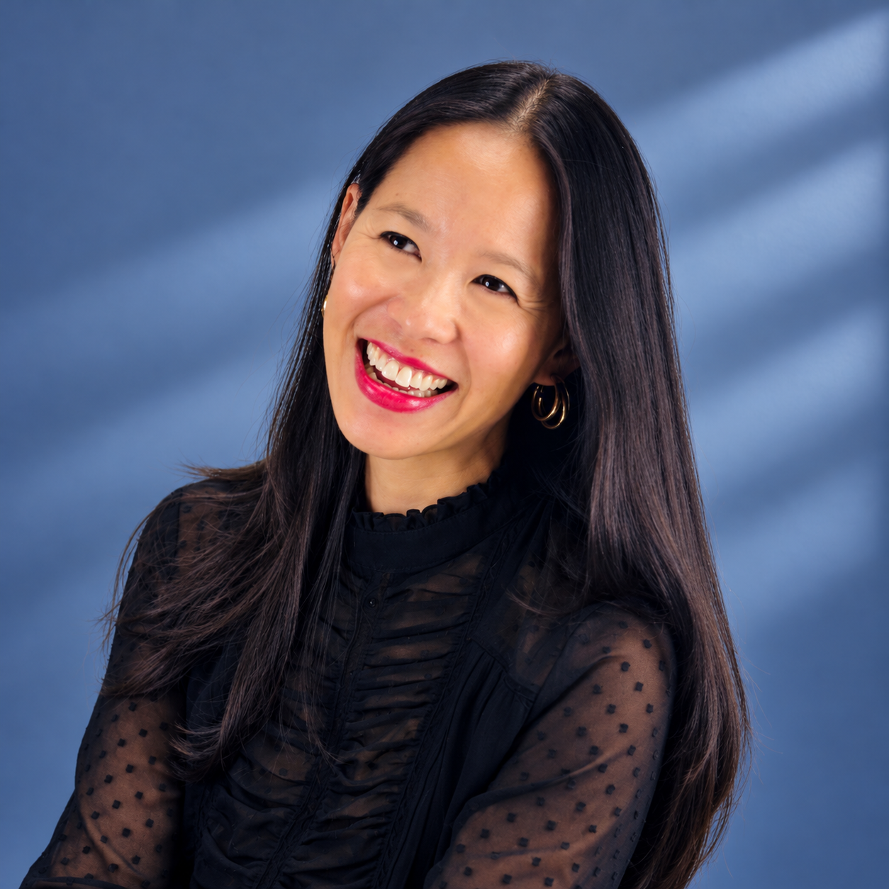 Headshot of smiling female tutor with long braids wearing a lanyard.