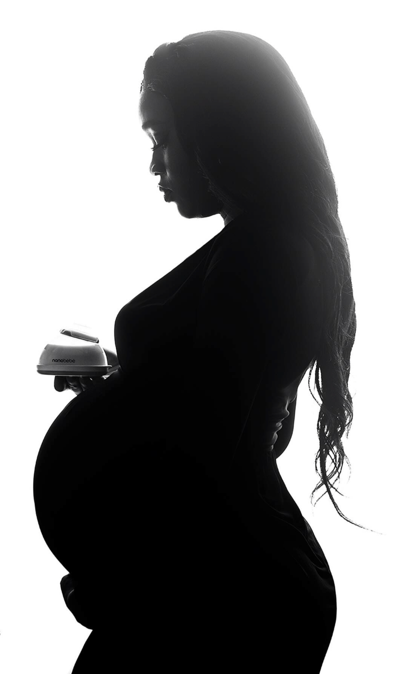 High-contrast black and white studio portrait of a pregnant woman highlighting body contours and silhouette in London.