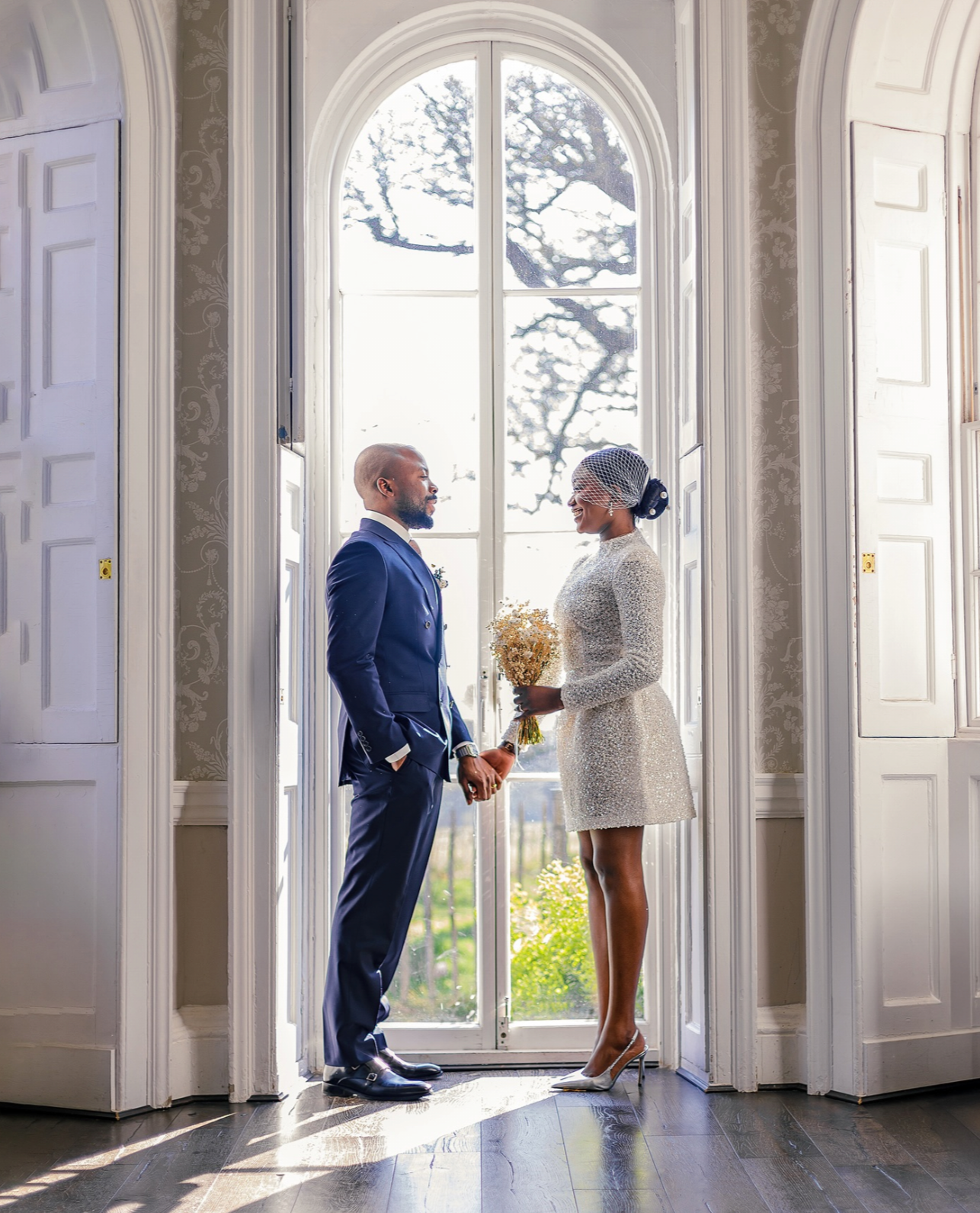 Newlywed bride and groom standing outside a colorful Victorian townhouse after an intimate Notting Hill wedding.