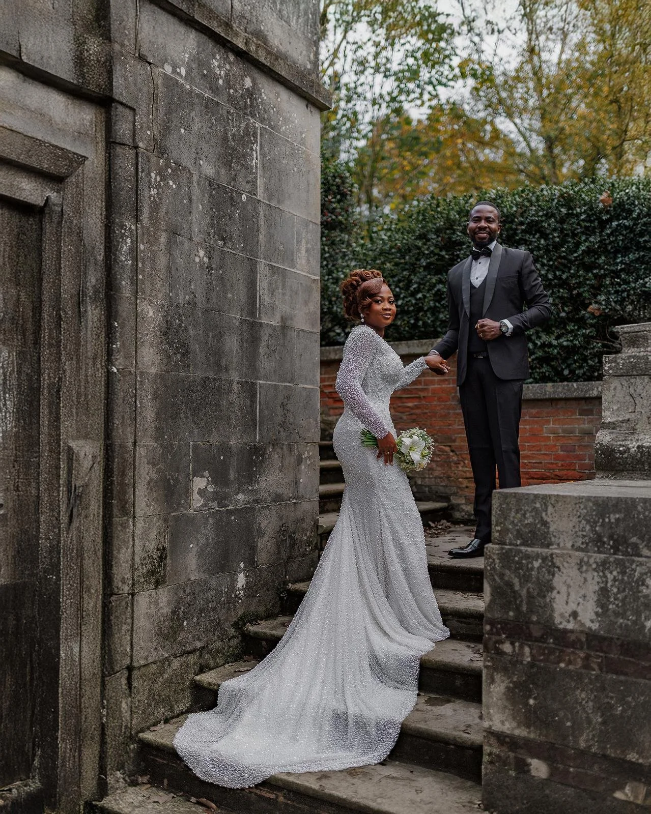 Bride and groom sharing a quiet laugh on the manicured lawns of a historic country manor near Birmingham.