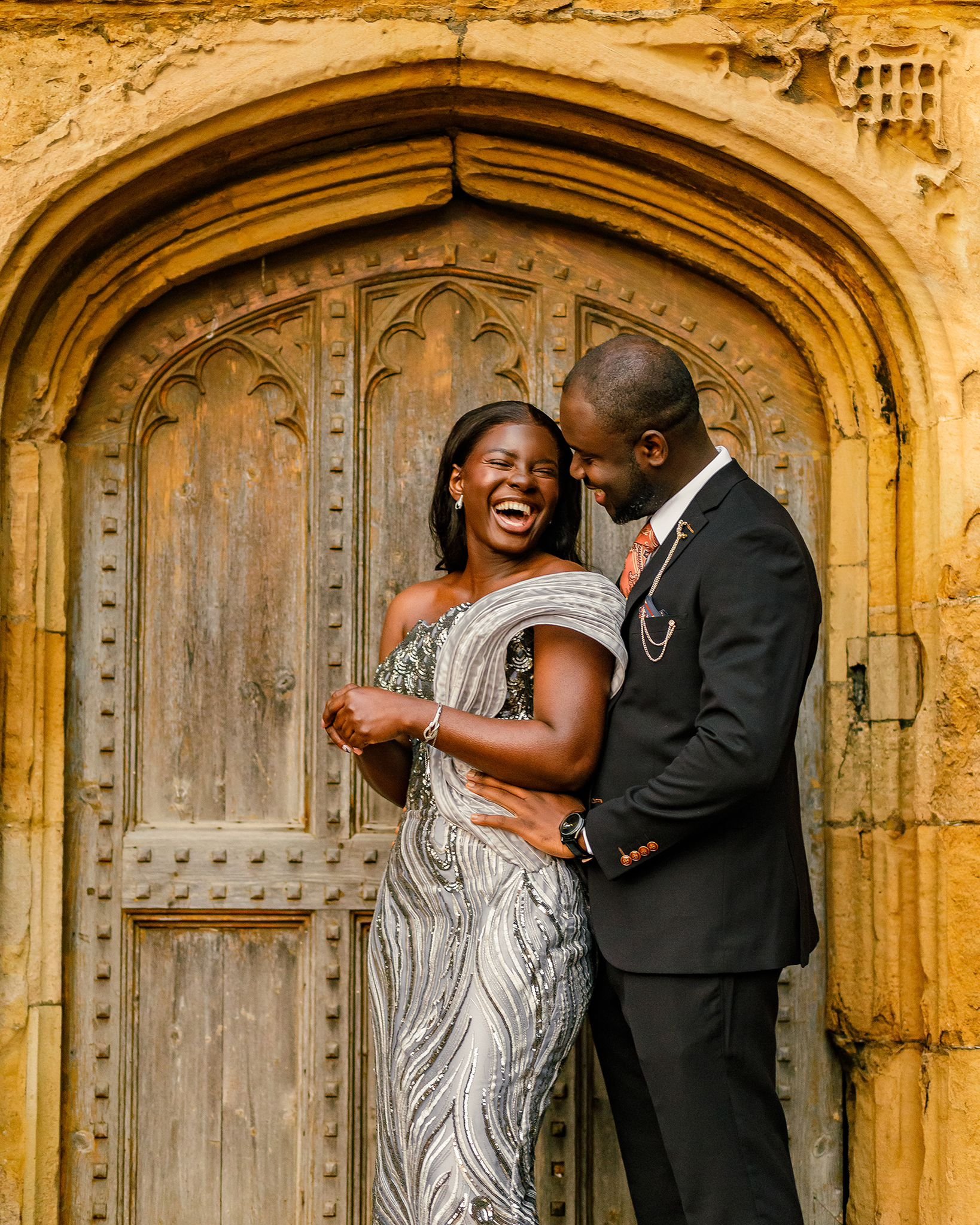 Bride and groom holding hands on the grand staircase during a modern city wedding at St Pancras London.