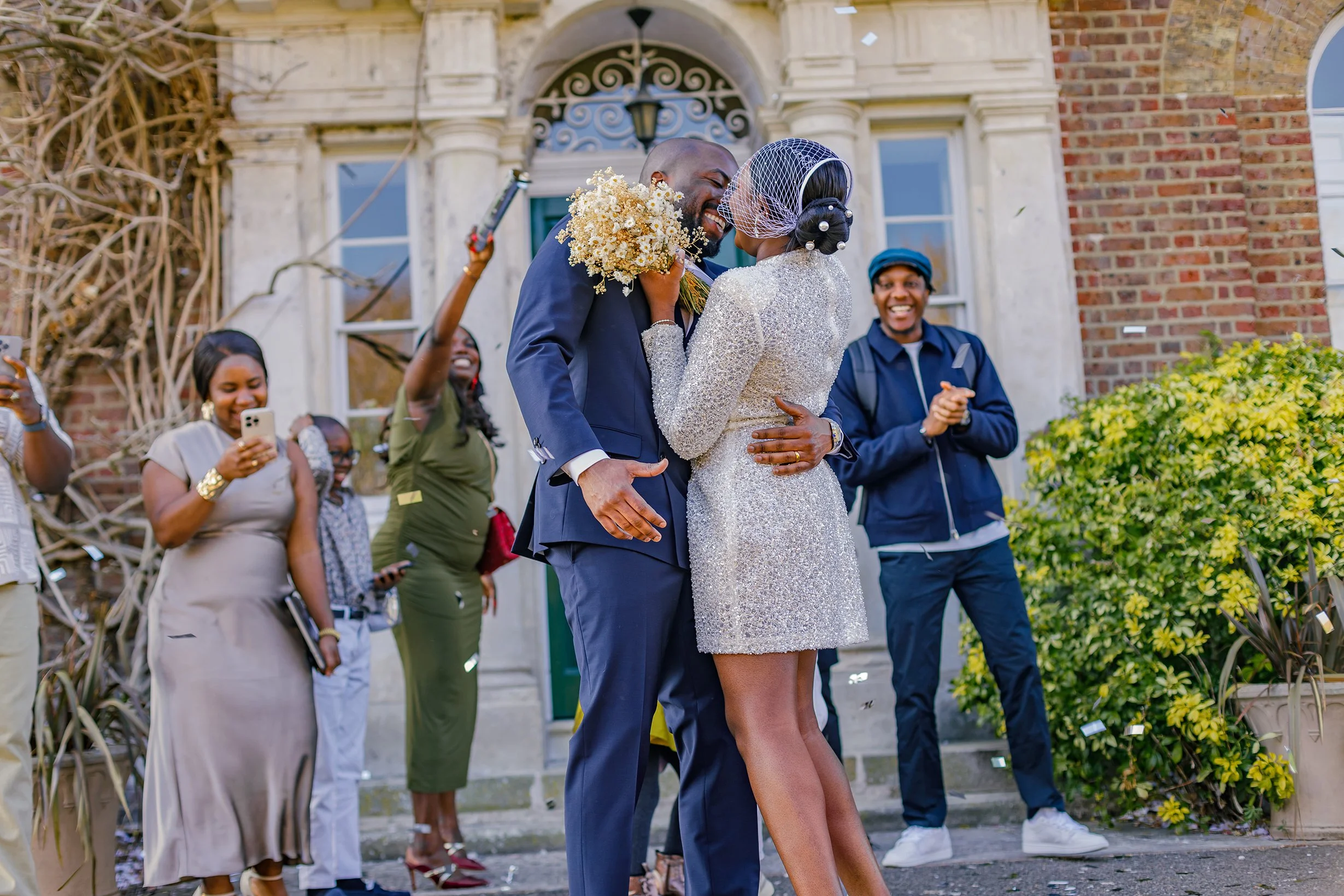 Guests throwing confetti over the newly married couple on the lawn outside Merton Register Office.