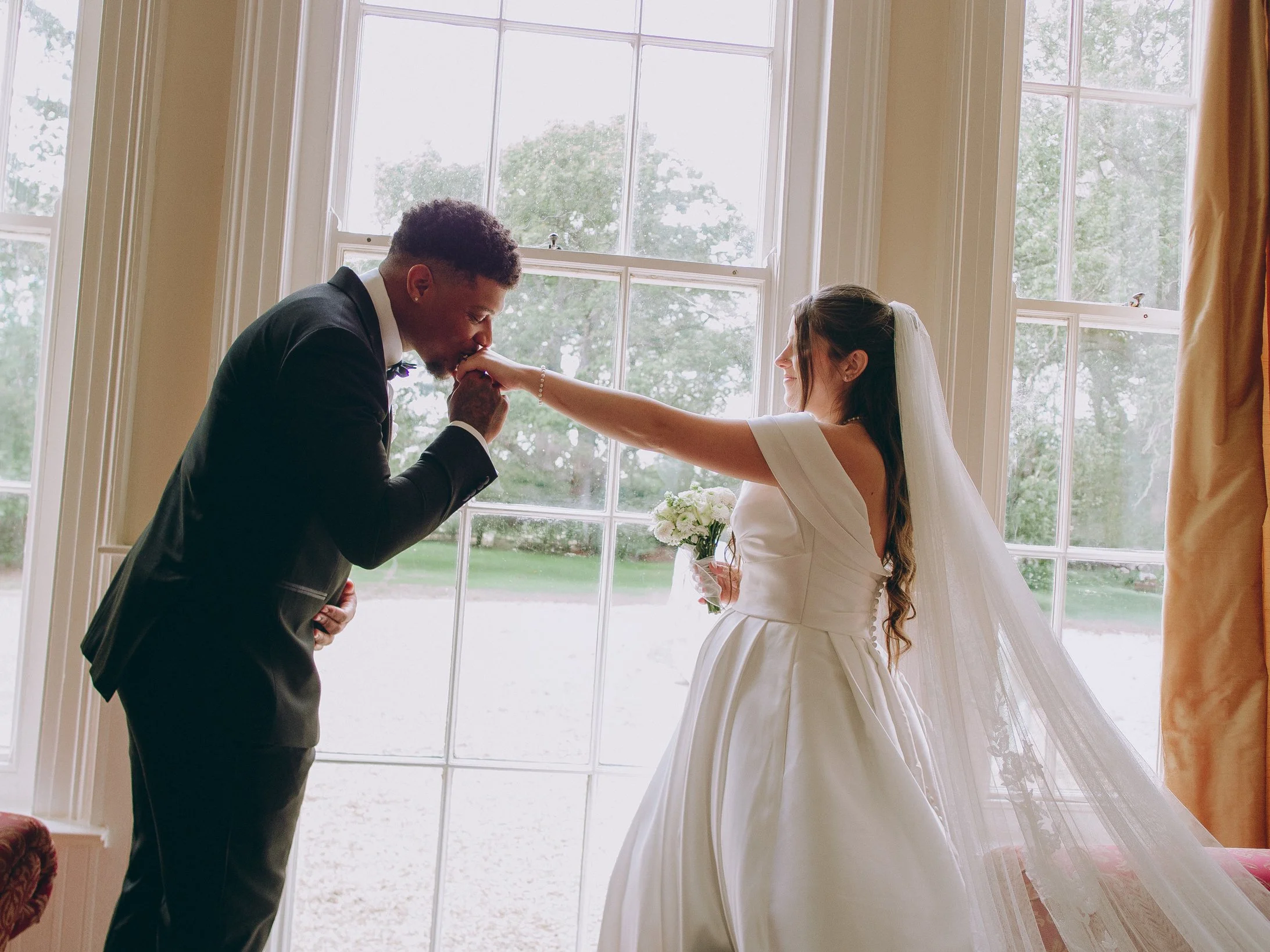 Bride and groom holding hands on the manicured lawns during a luxury estate wedding at Woodhall Spa Manor in Lincolnshire.