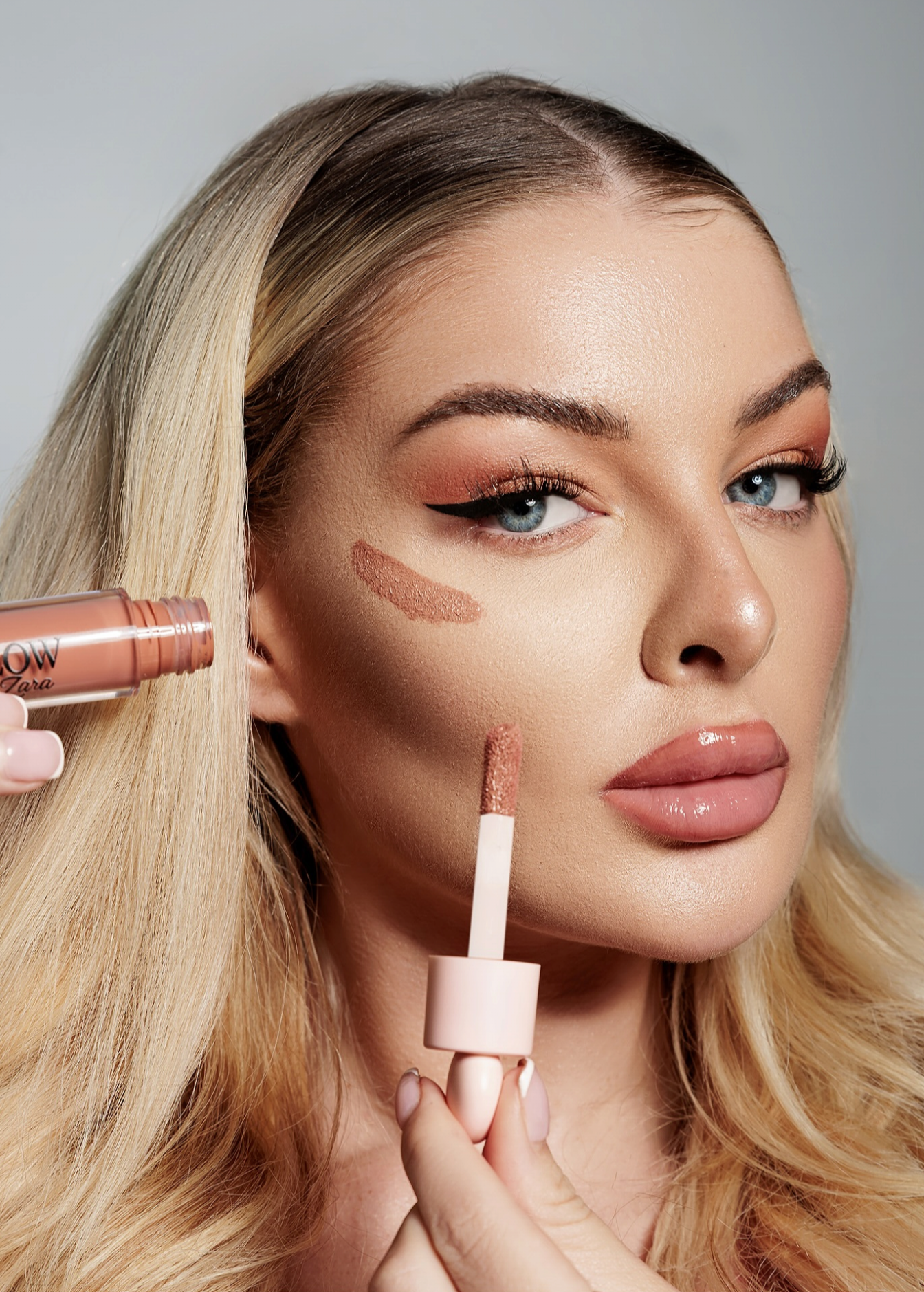 Model displaying natural skin texture and luminous glow during a high-key skincare campaign shoot in a London studio.