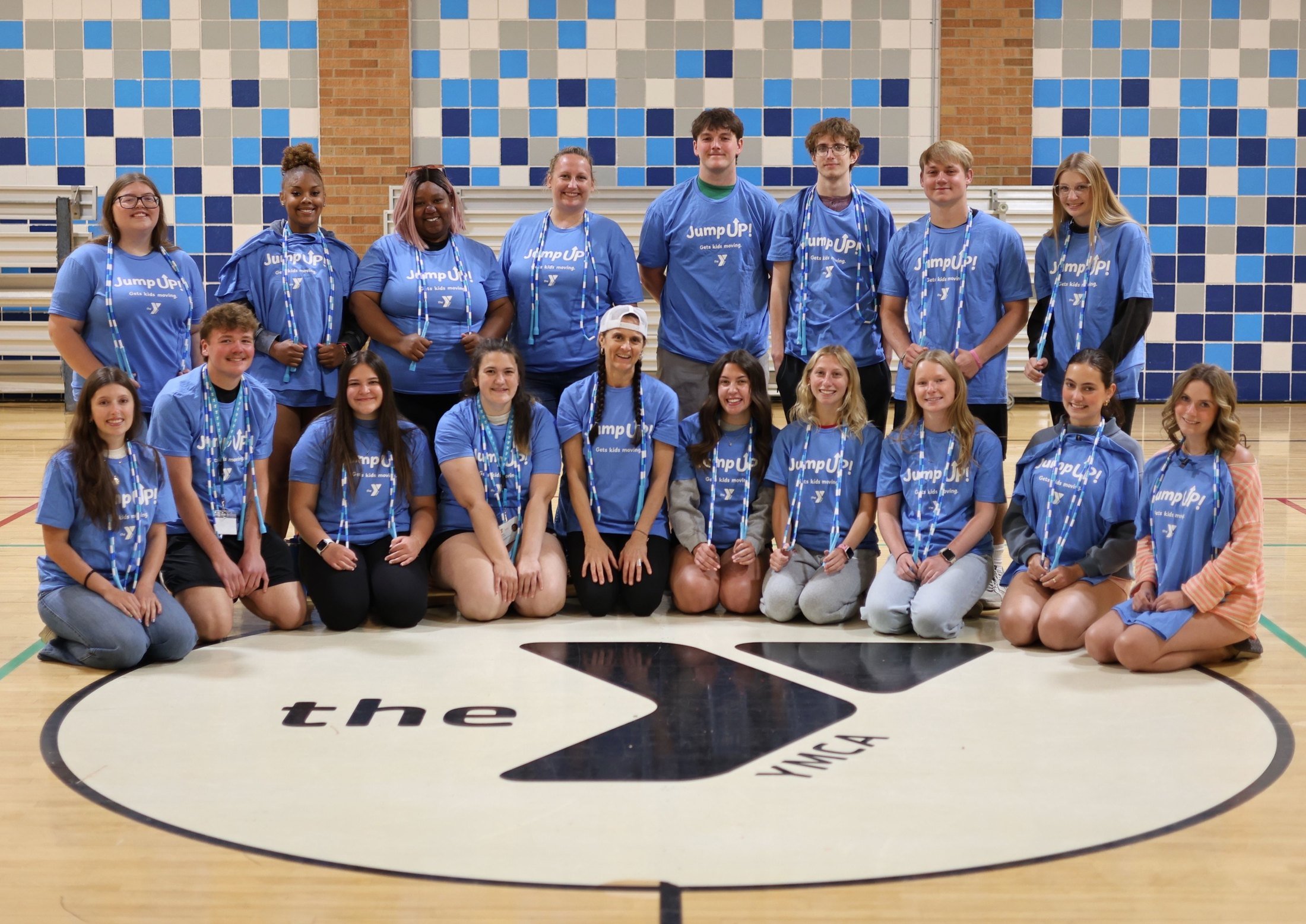 YMCA staff and teen leaders in Jump UP! t-shirts with beaded jump ropes, posed on a gym floor