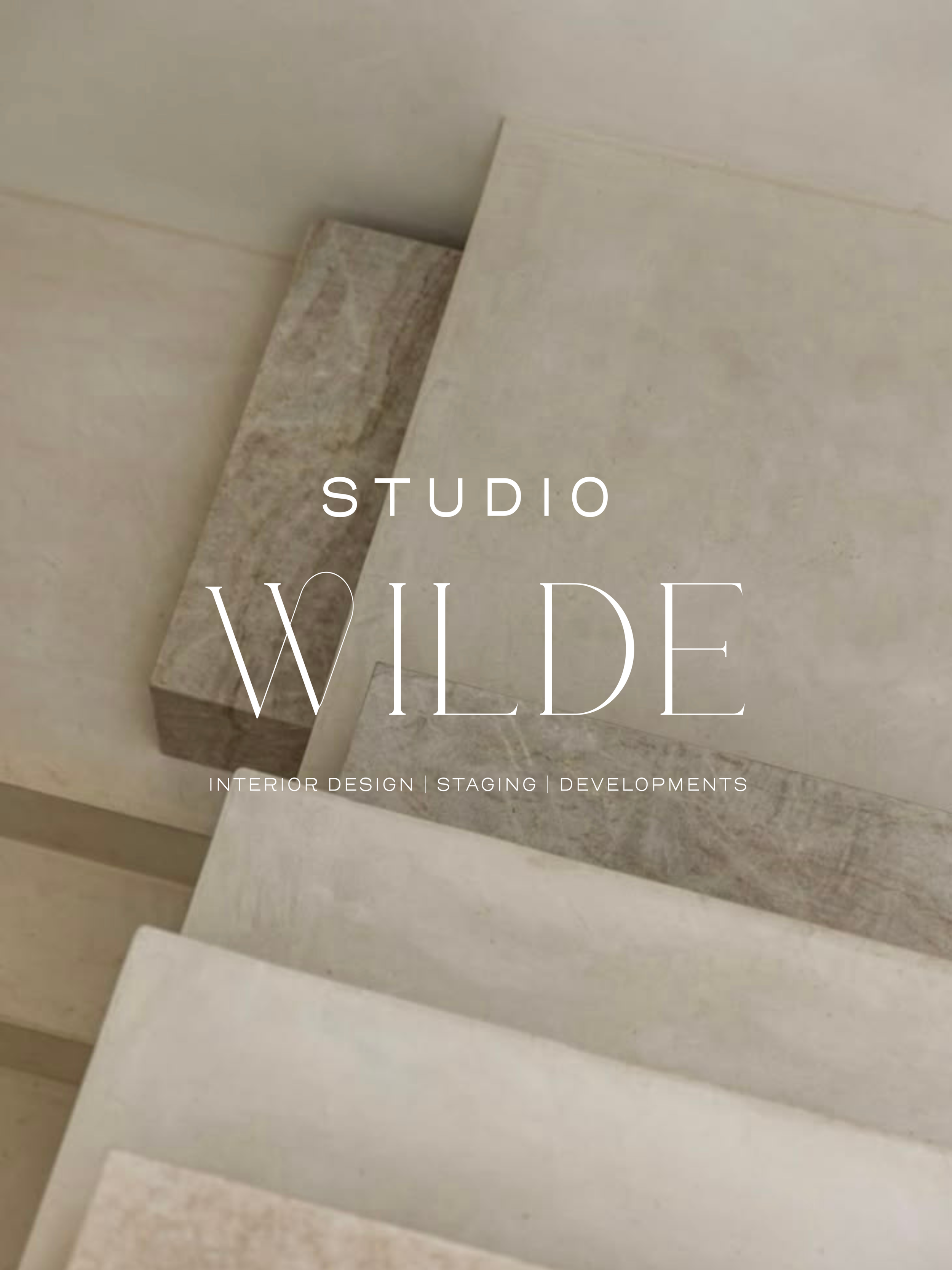 Close-up of architectural or interior design material, possibly stone or tile with a smooth, light-colored surface and a textured edge, with text overlay reading 'Studio Wilde' and additional words related to interior design, staging, and development.