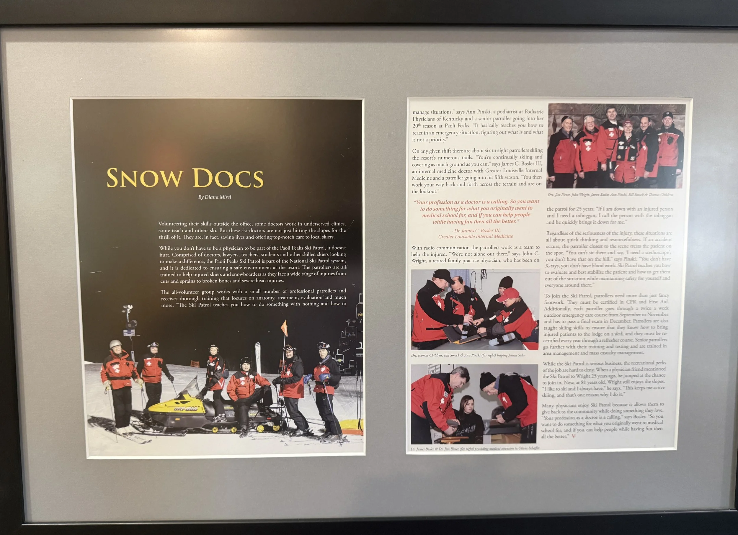 A display board with a photo of several people dressed in red snow gear, standing on snow with a yellow snowmobile in front of them, and a group photo of ski patrol members in red jackets. The board contains text about ski patrol, medical volunteers, and emergency response in snowy conditions.