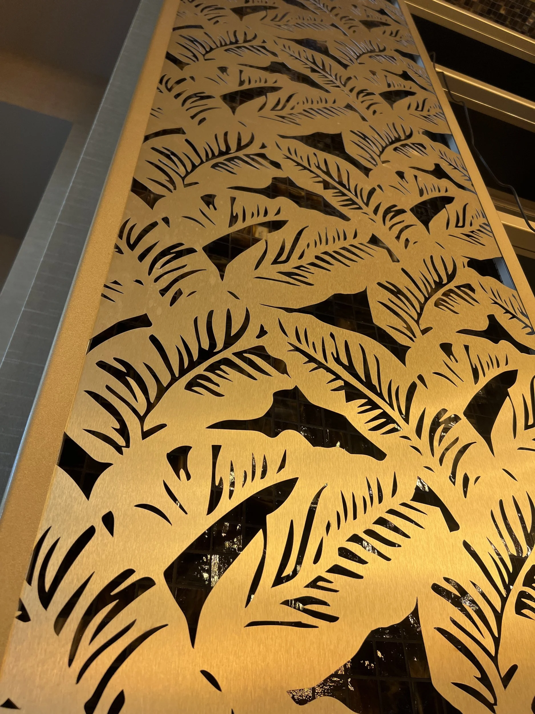 Close-up of laser-cut brass palm-leaf panel at SAHARA's AZILO Ultra Lounge