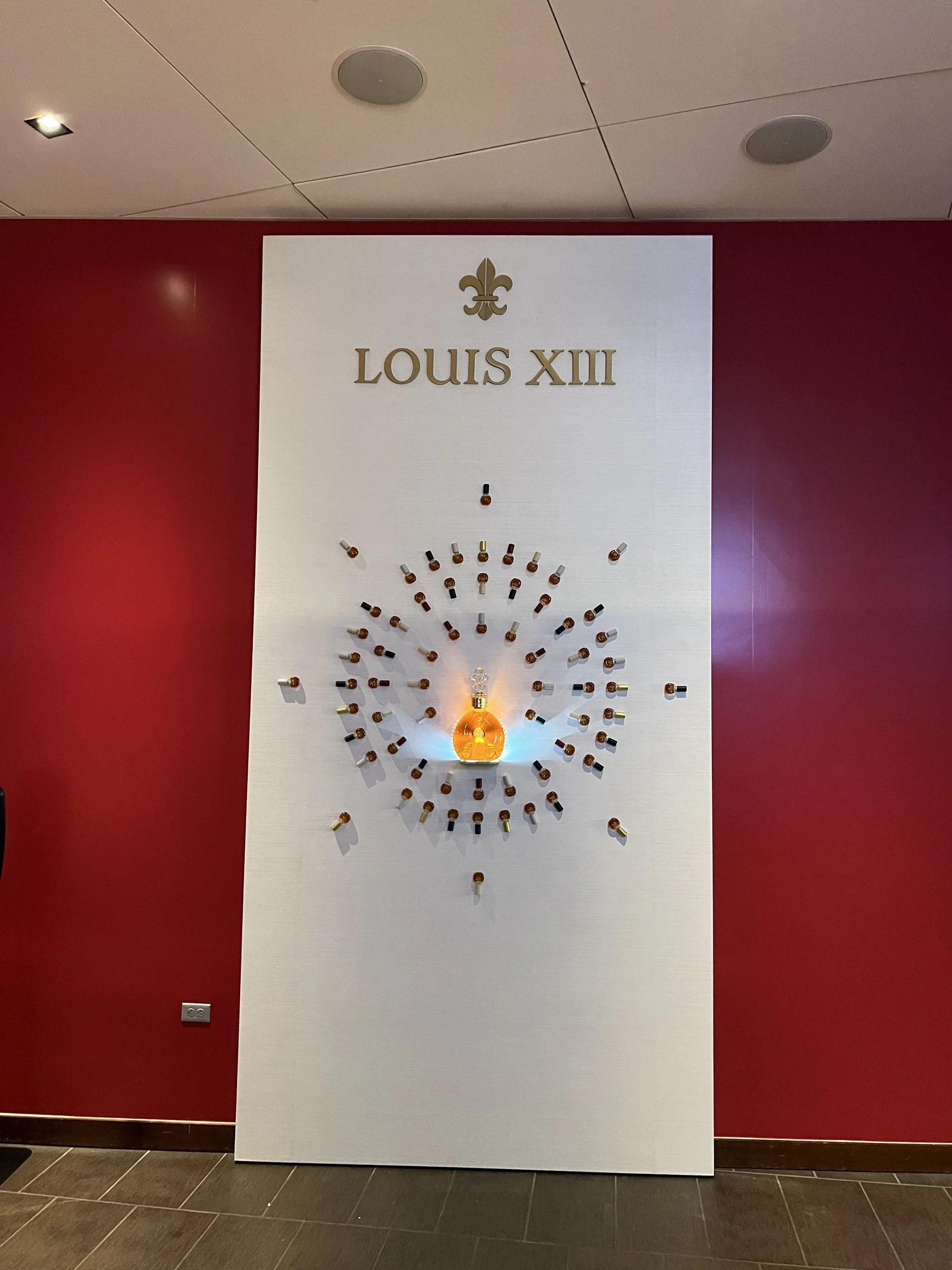 Louis XIII brand wall with a radiating ring of decanters around a lit crystal centerpiece