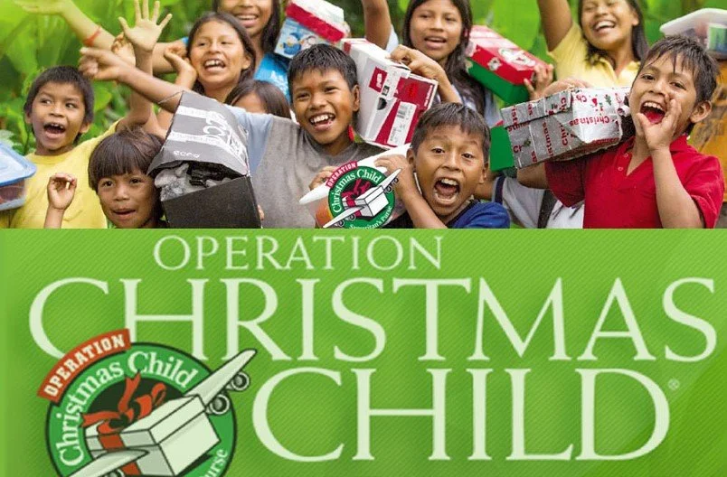 A group of children smiling and holding Christmas presents, celebrating during Operation Christmas Child charity event.