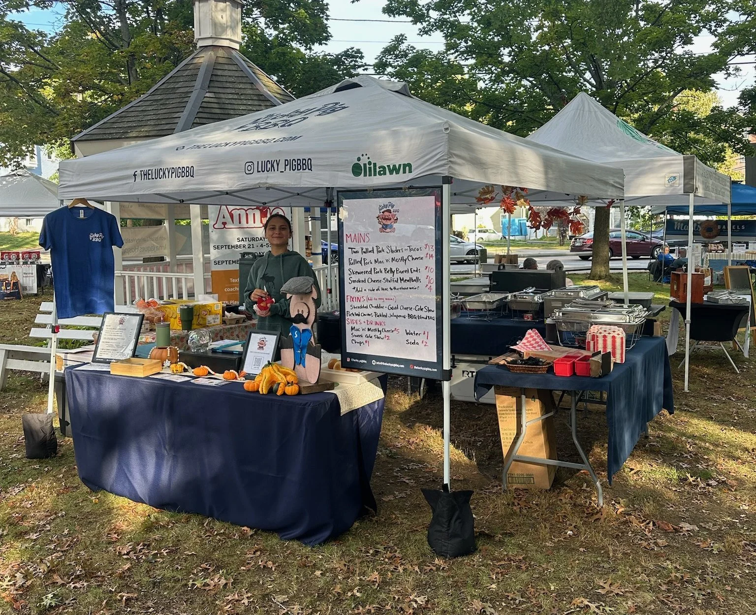 The Lucky Pig BBQ pop-up tent and menu board at a fall event
