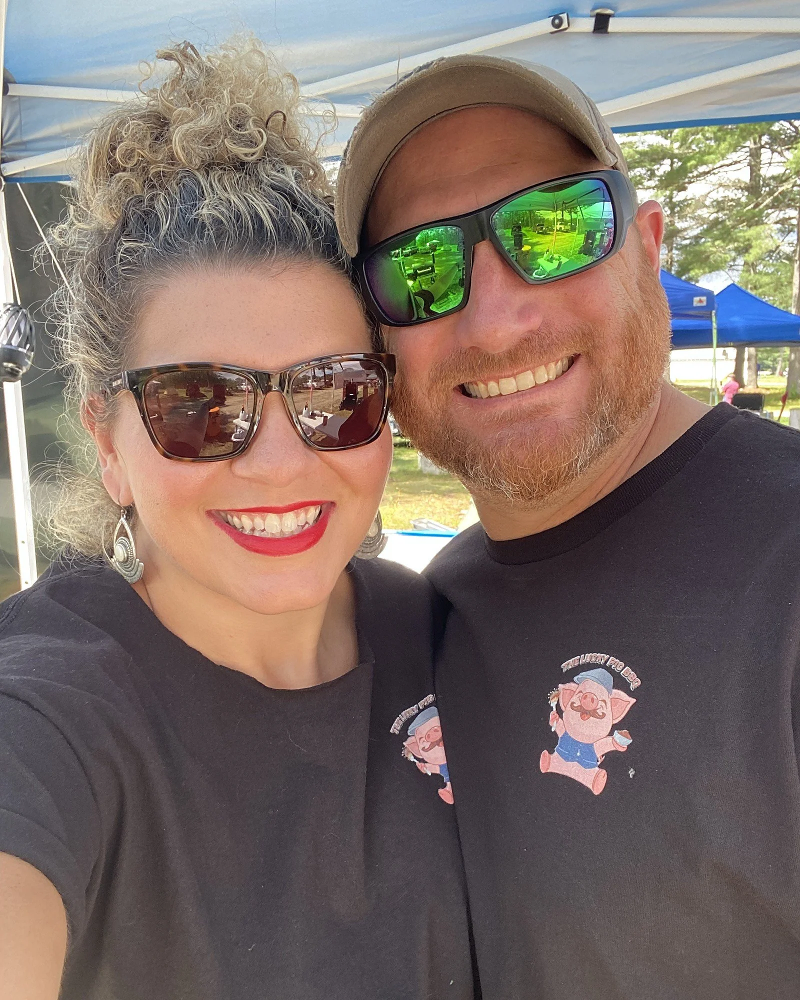 Fred and Ashley in Lucky Pig BBQ shirts at an event