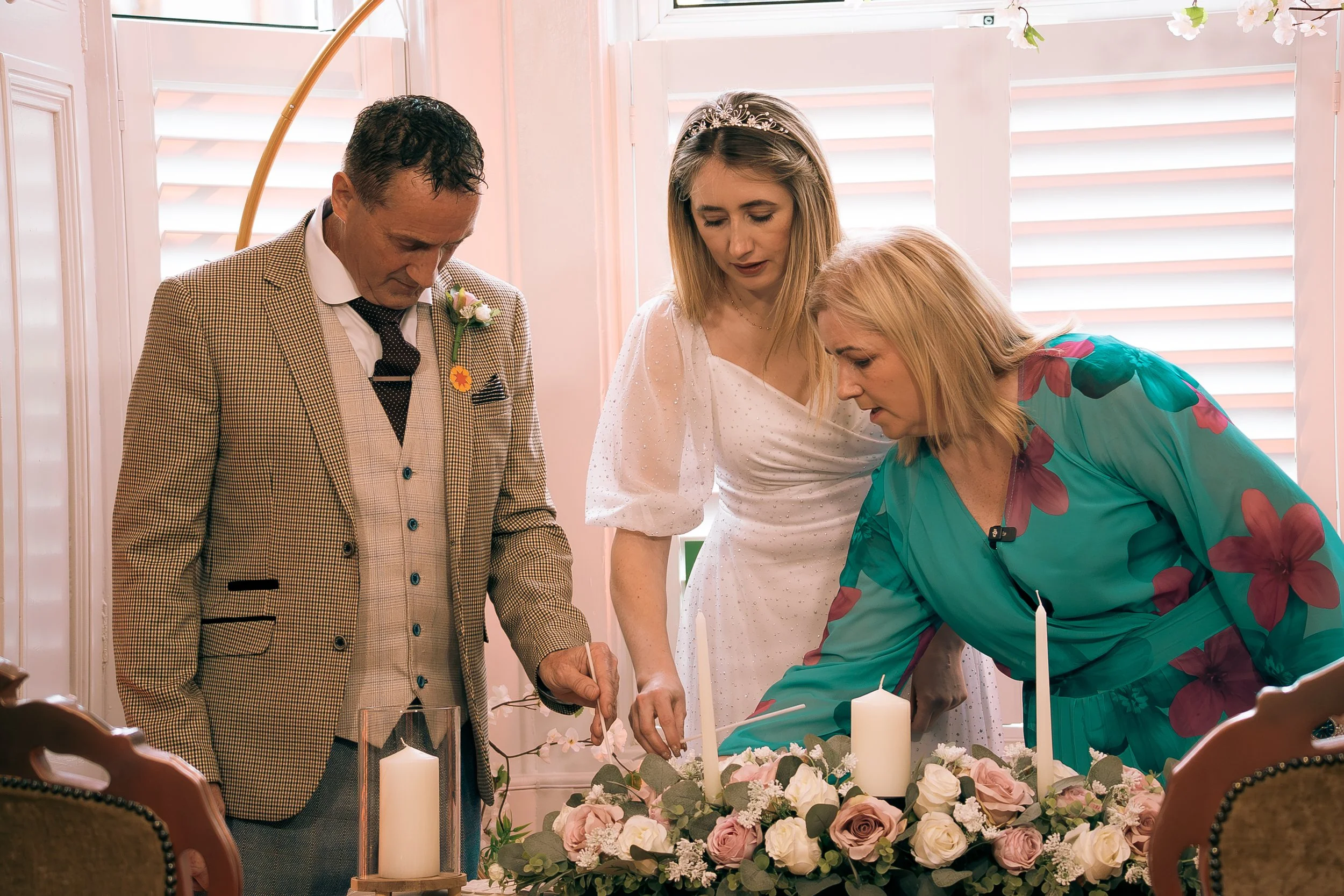 Karen O'Beirne with a wedding couple lighting their unity candles during their wedding ceremony