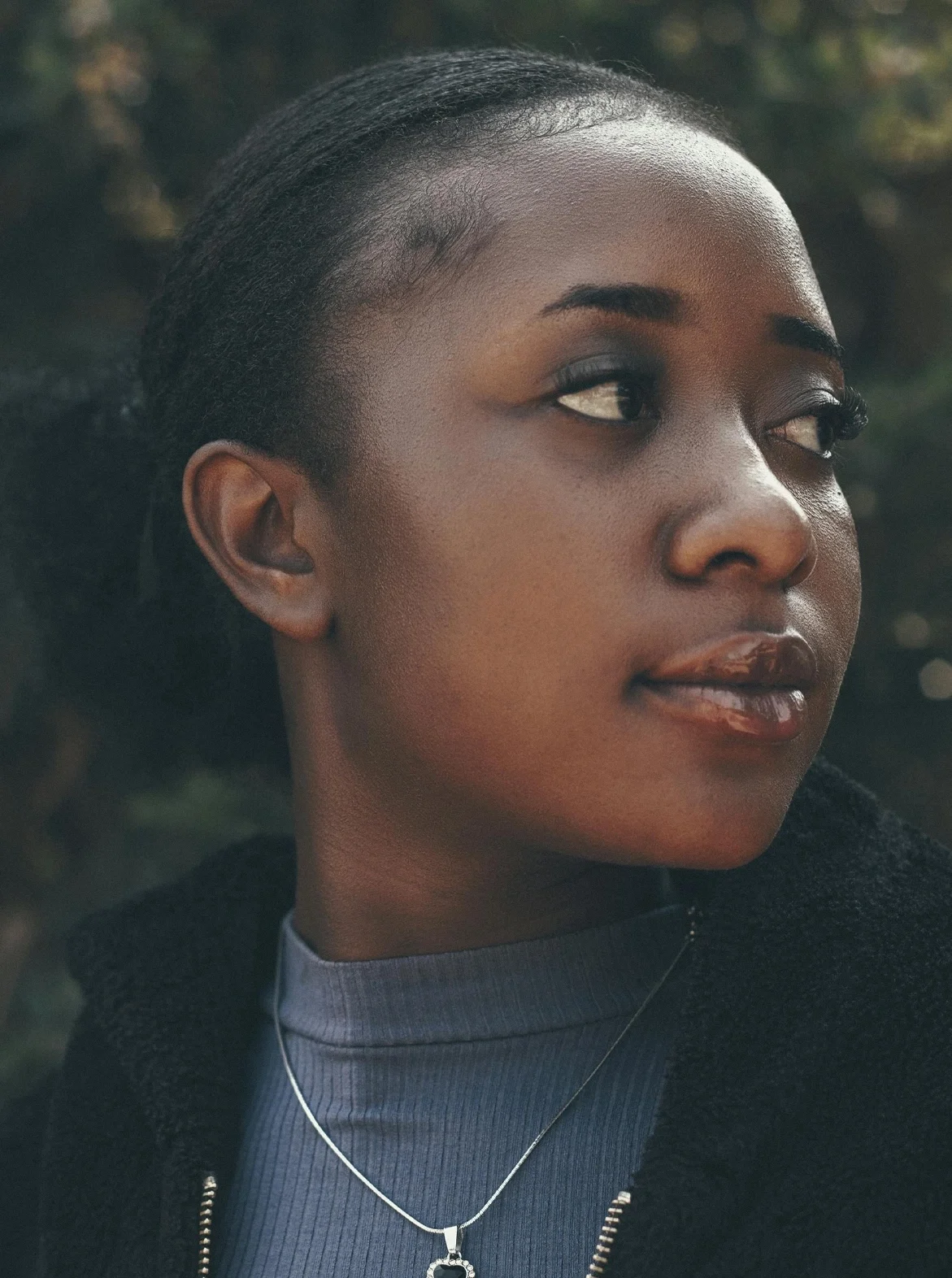 Photo portrait of proud black woman in jacket outdoors looking to right