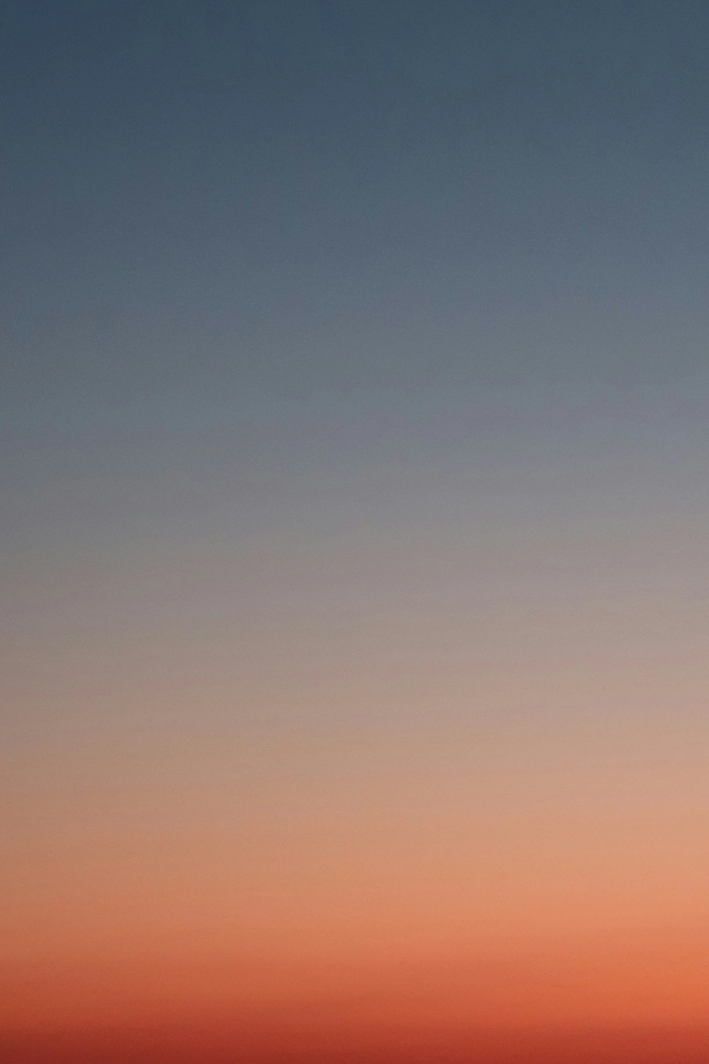 A gradient sky transitioning from dark blue at the top to a reddish hue at the bottom.