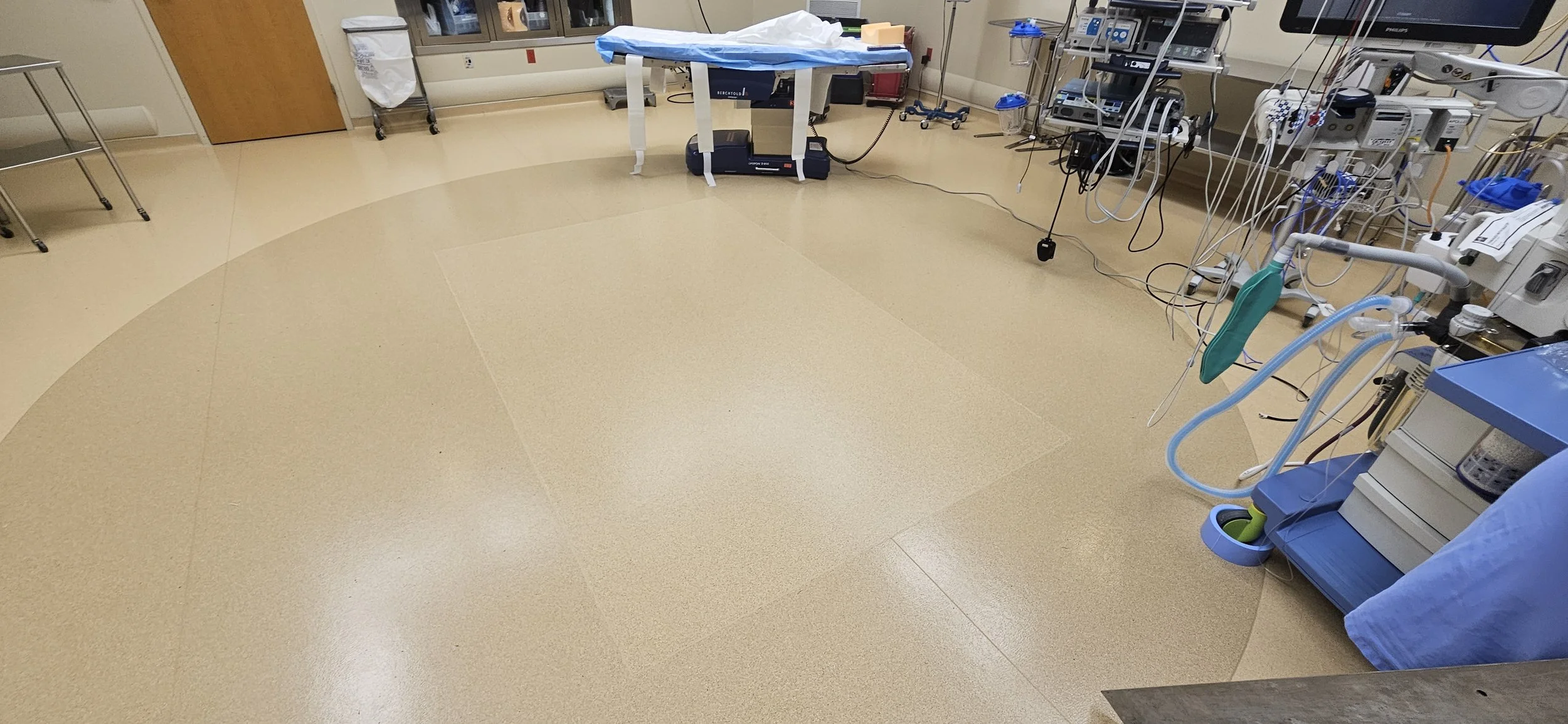 Empty hospital operating room or medical procedure room with medical equipment and instruments, no people present.
