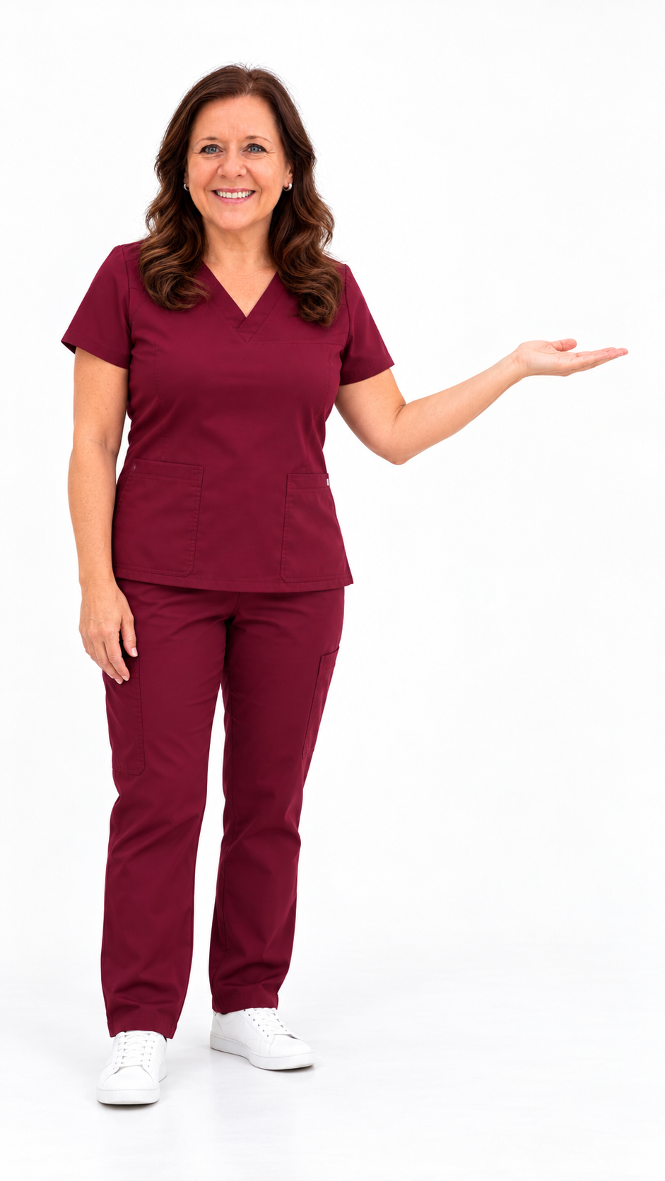 A woman in maroon medical scrubs smiling and gesturing with her right hand, standing against a white background.