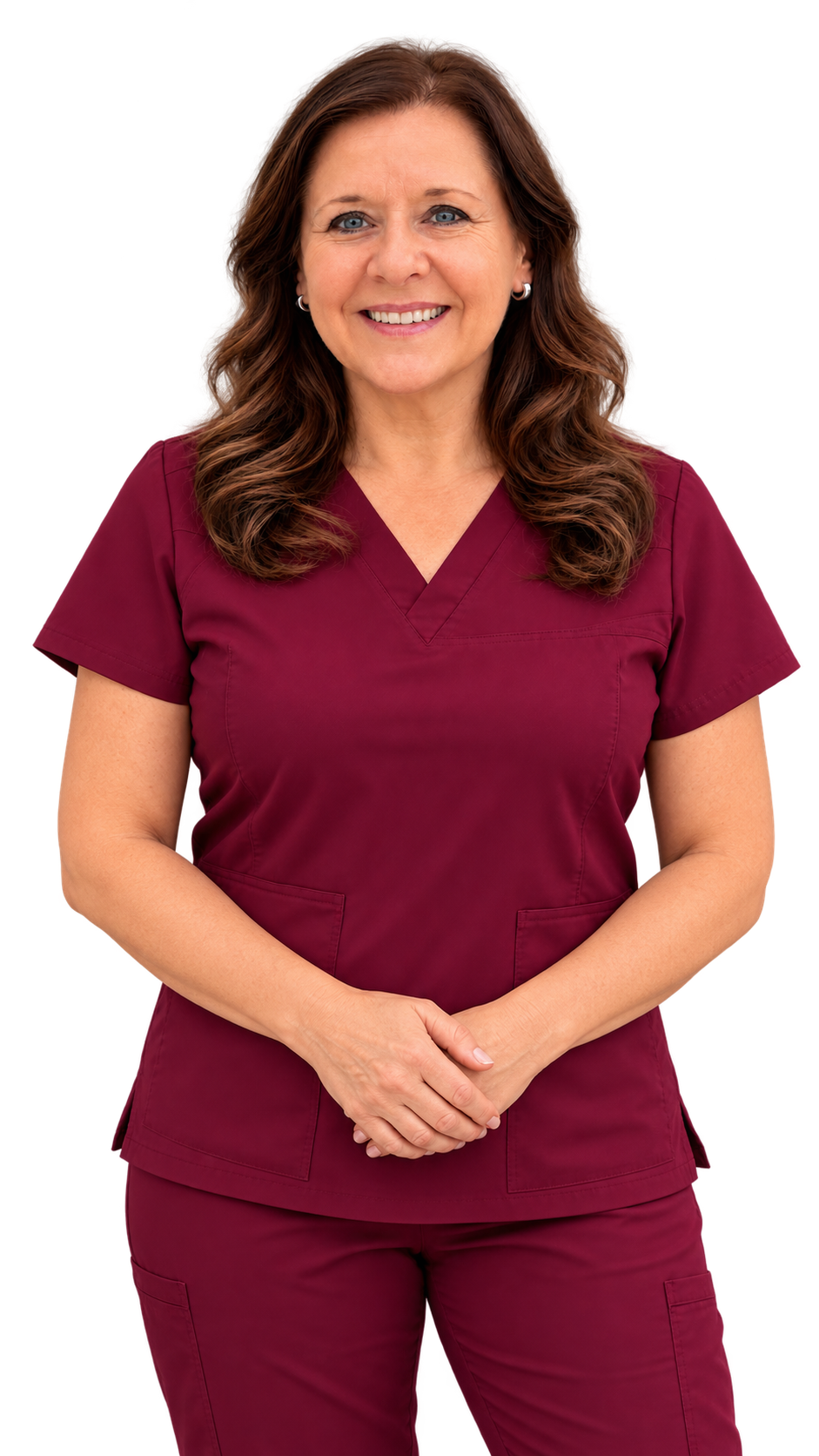 A smiling woman wearing maroon medical scrubs, standing with her hands clasped in front of her, against a plain background.